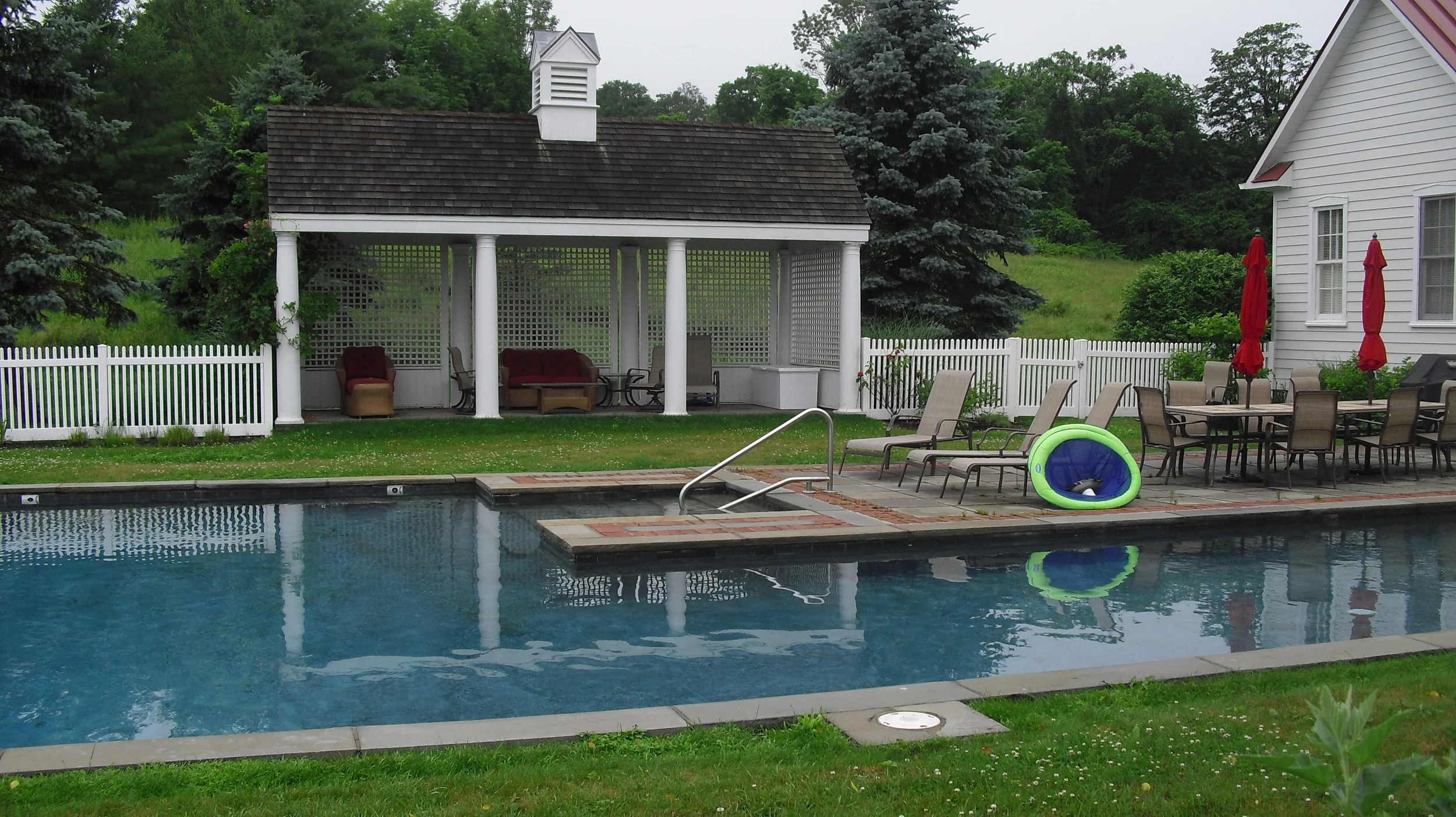 Before photo showing old pool house and old patio