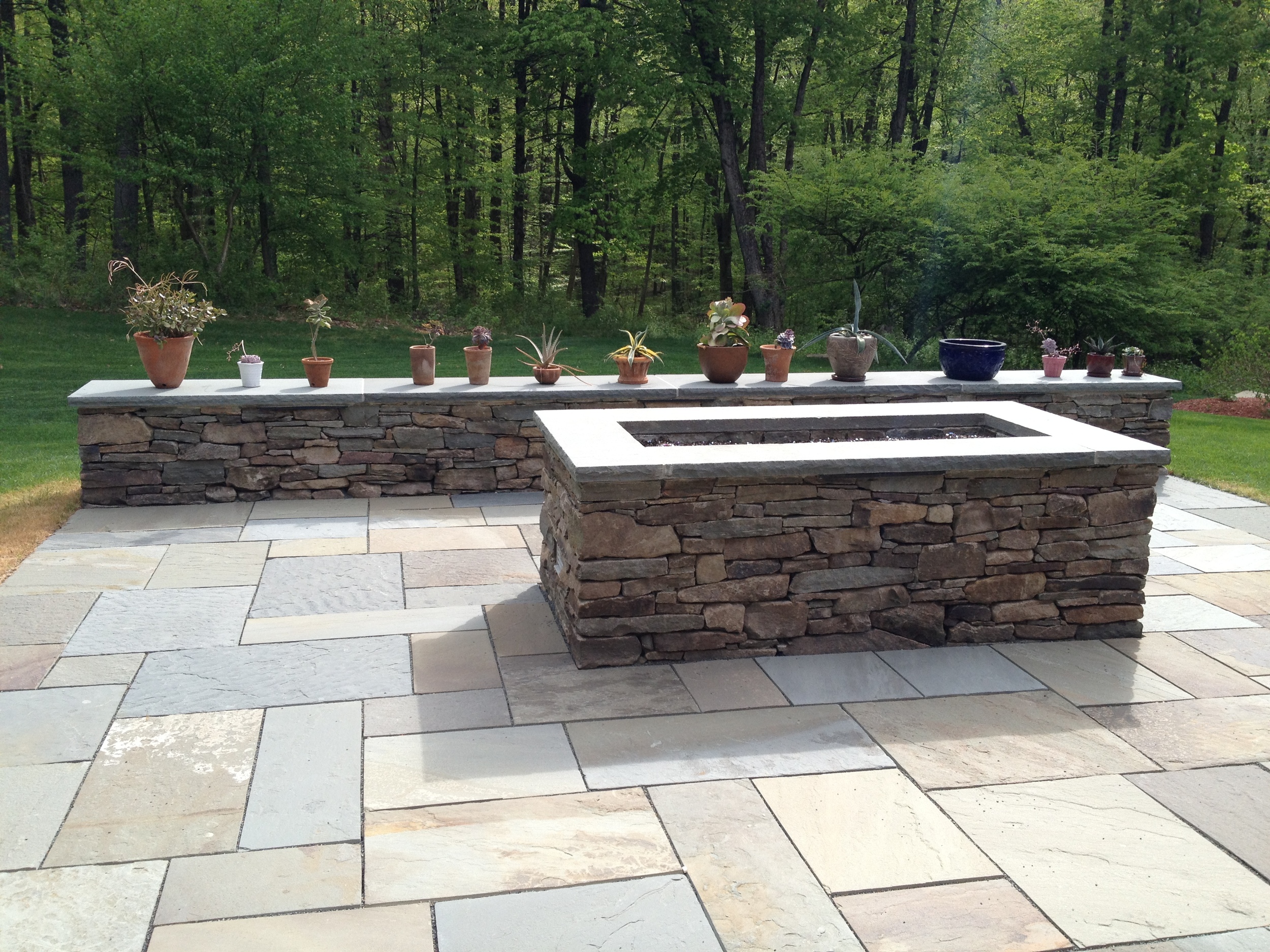 Modern fire pit in fieldstone with bluestone patio