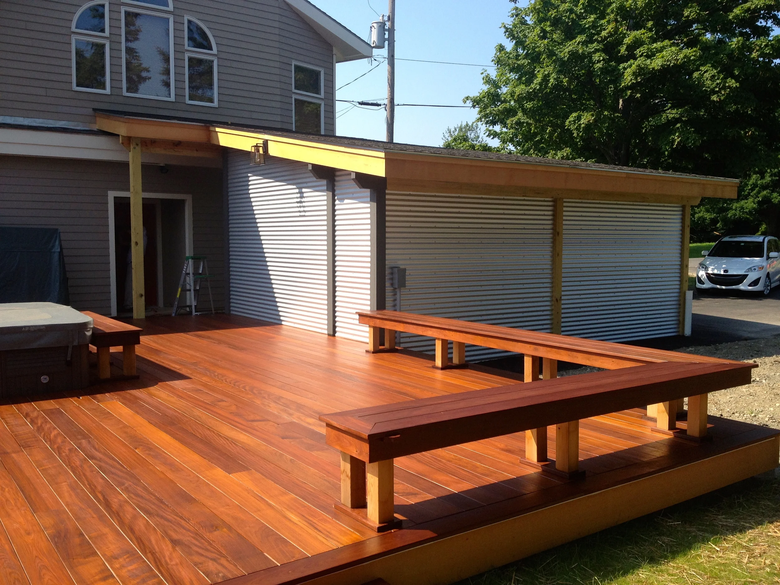 New deck with bench and galvanized siding on carport