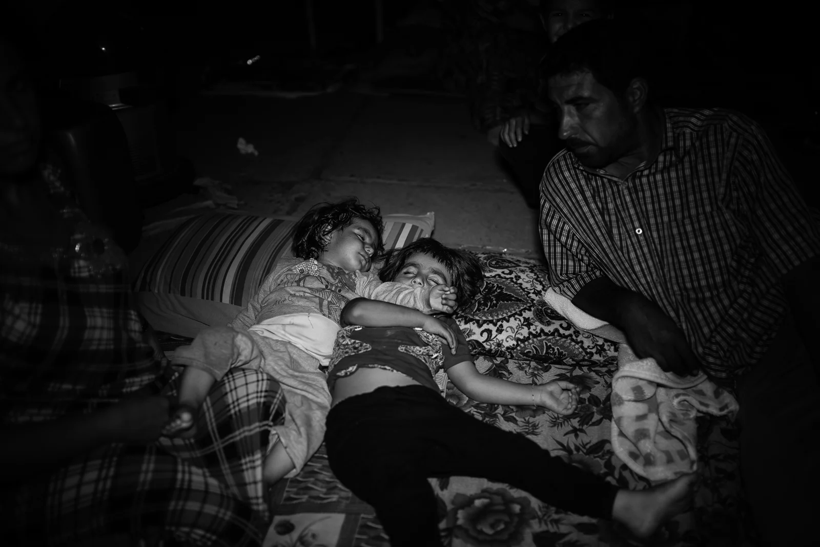 Children sleeping on the floor of a school's garden in Zakho