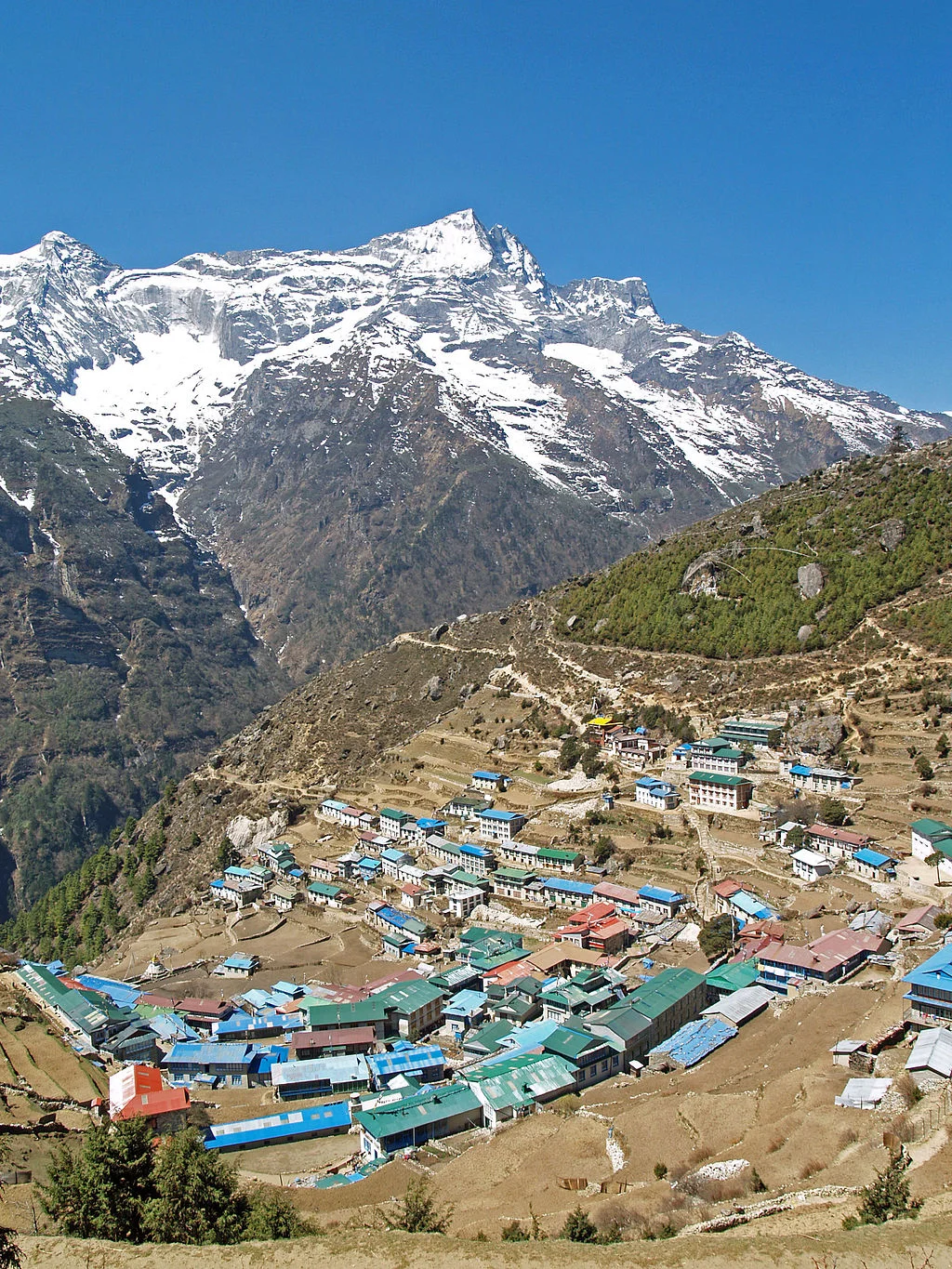 Namche Bazaar&nbsp;village located at 3,440 metres (11,286 ft) above the sea level in&nbsp;Khumbu region, northeastern&nbsp;Nepal. The&nbsp;Kongde Ri peakb&nbsp;with its 6,187 m (20,299 ft) can be seen in the background. Photo by stevehicks [CC-BY-2…
