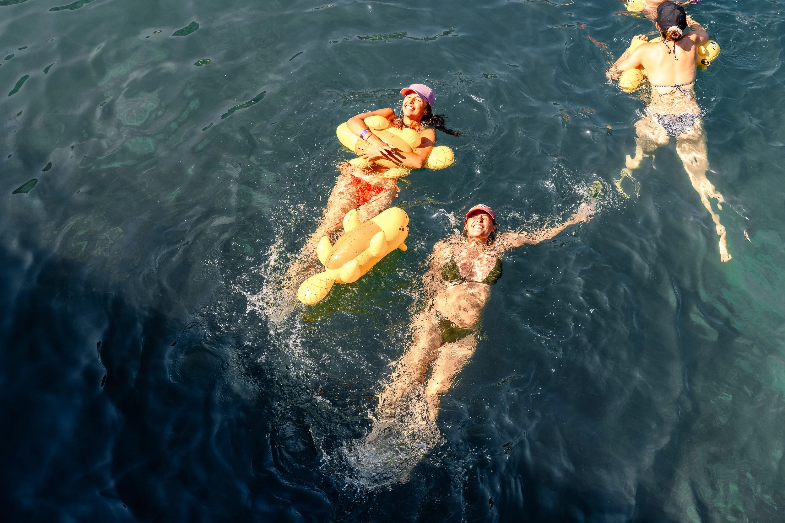 Limmatschwimmen Zürich: swimmers on yellow inflatables seen from above in clear water / Schwimmende auf gelben Schwimmtieren von oben im klaren Wasser