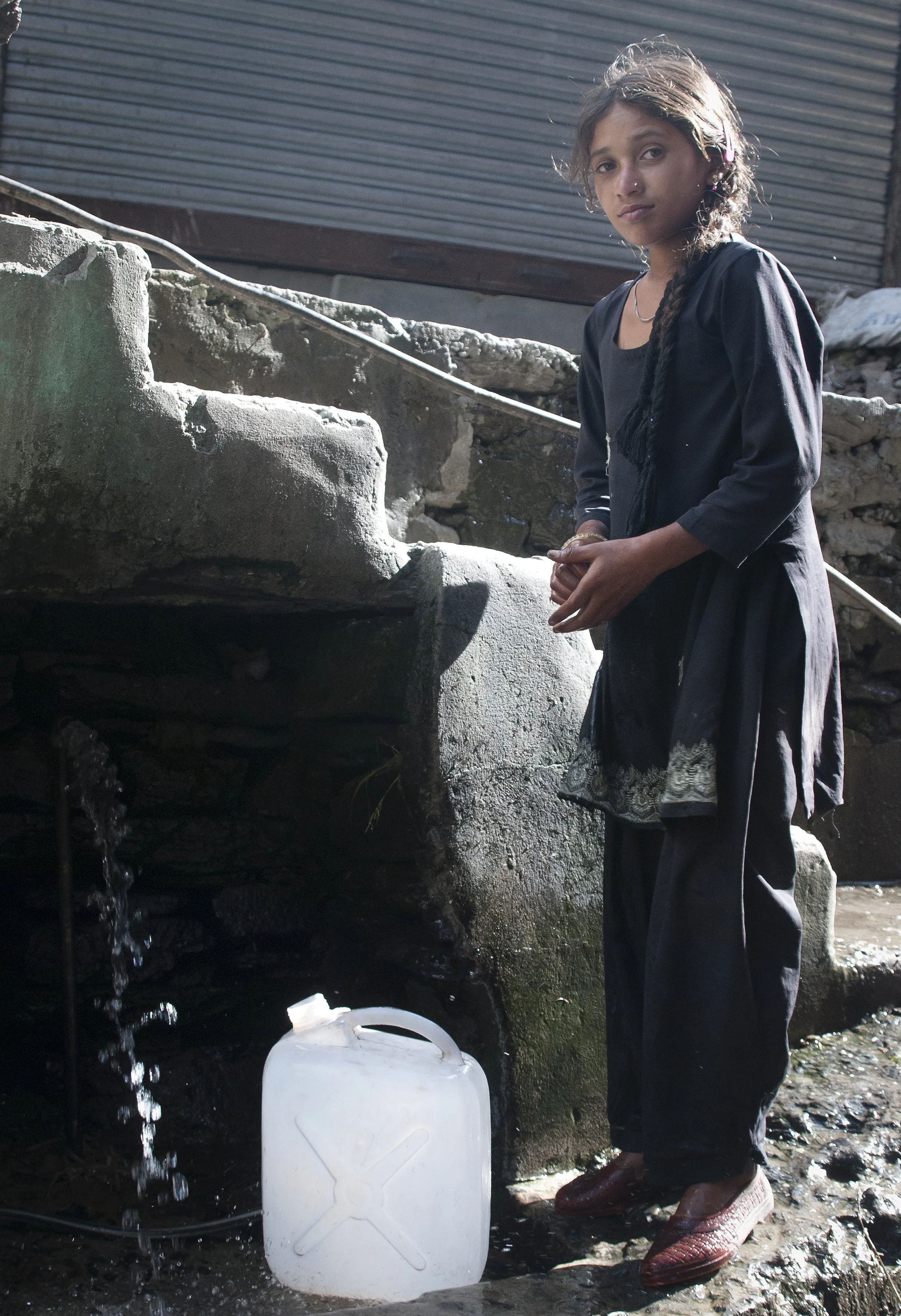 A young girl from the village collects water for her family. 