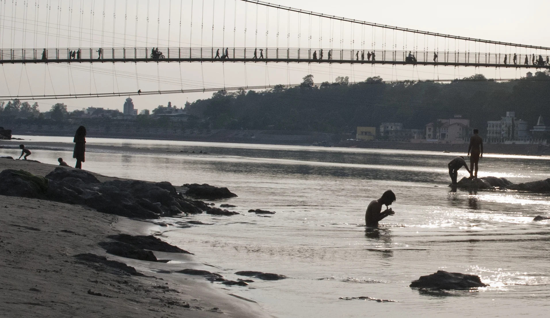 Underneath Ram Jhula bridge pilgrims and locals bathe in the holy water of the Ganges.
