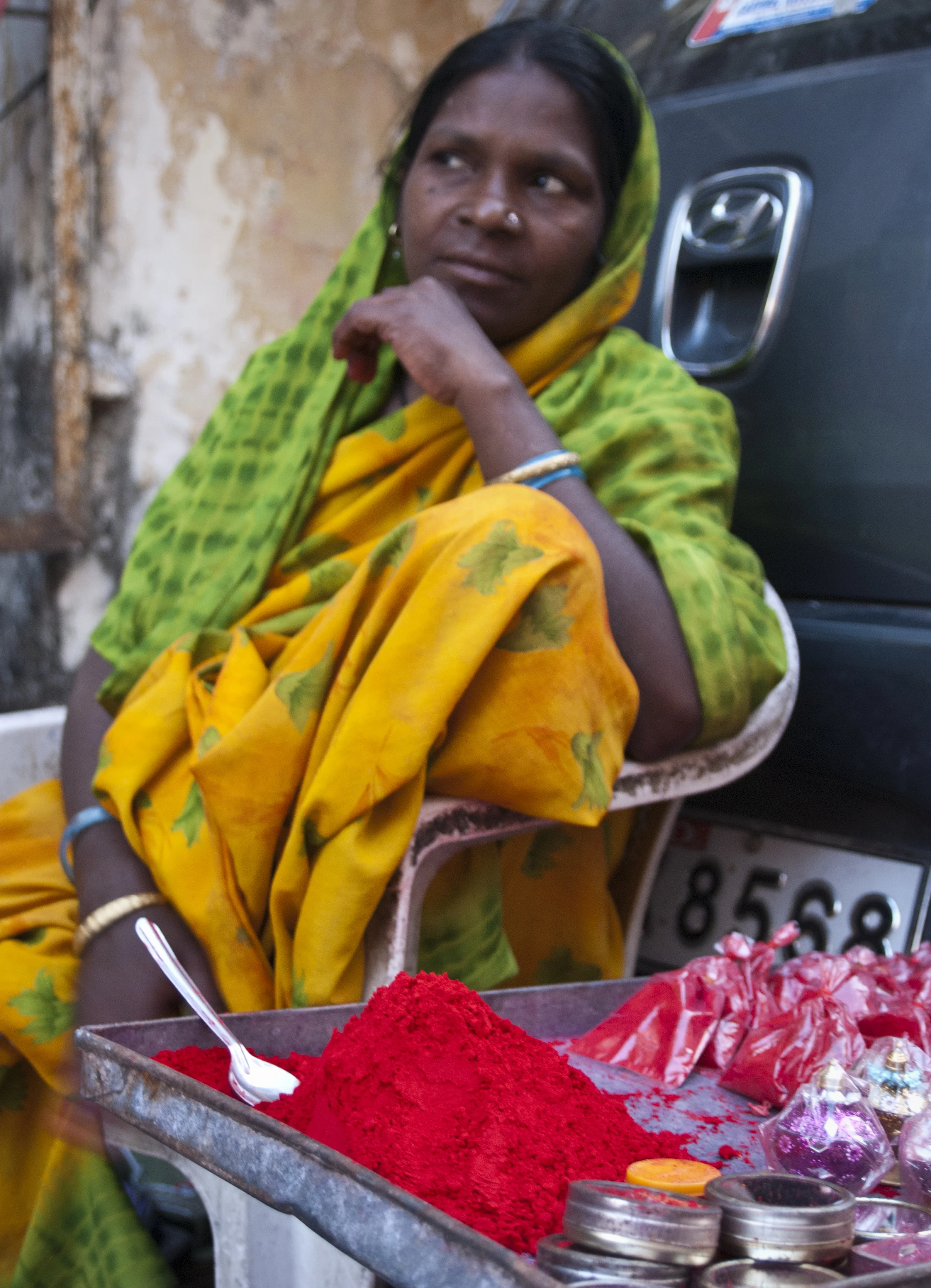A woman sells vermillion powder. The powder is applied between the eyebrows to signify the third eye and the sixth chakra.