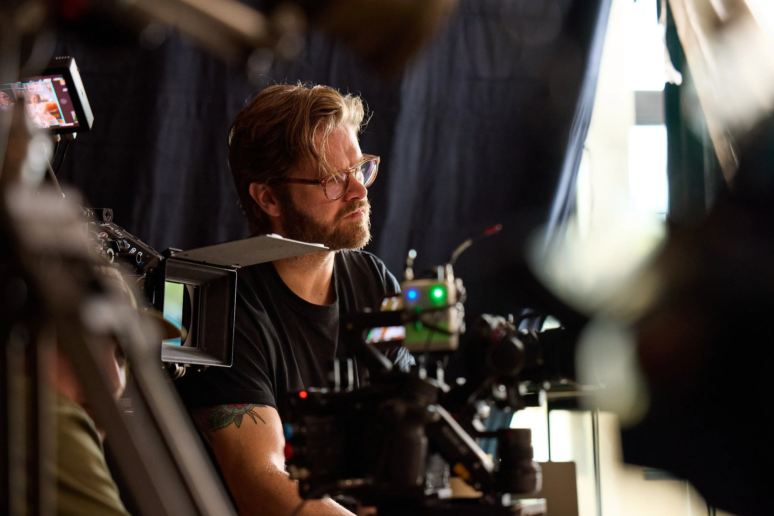 Filmmaker operating camera behind the scenes during production.