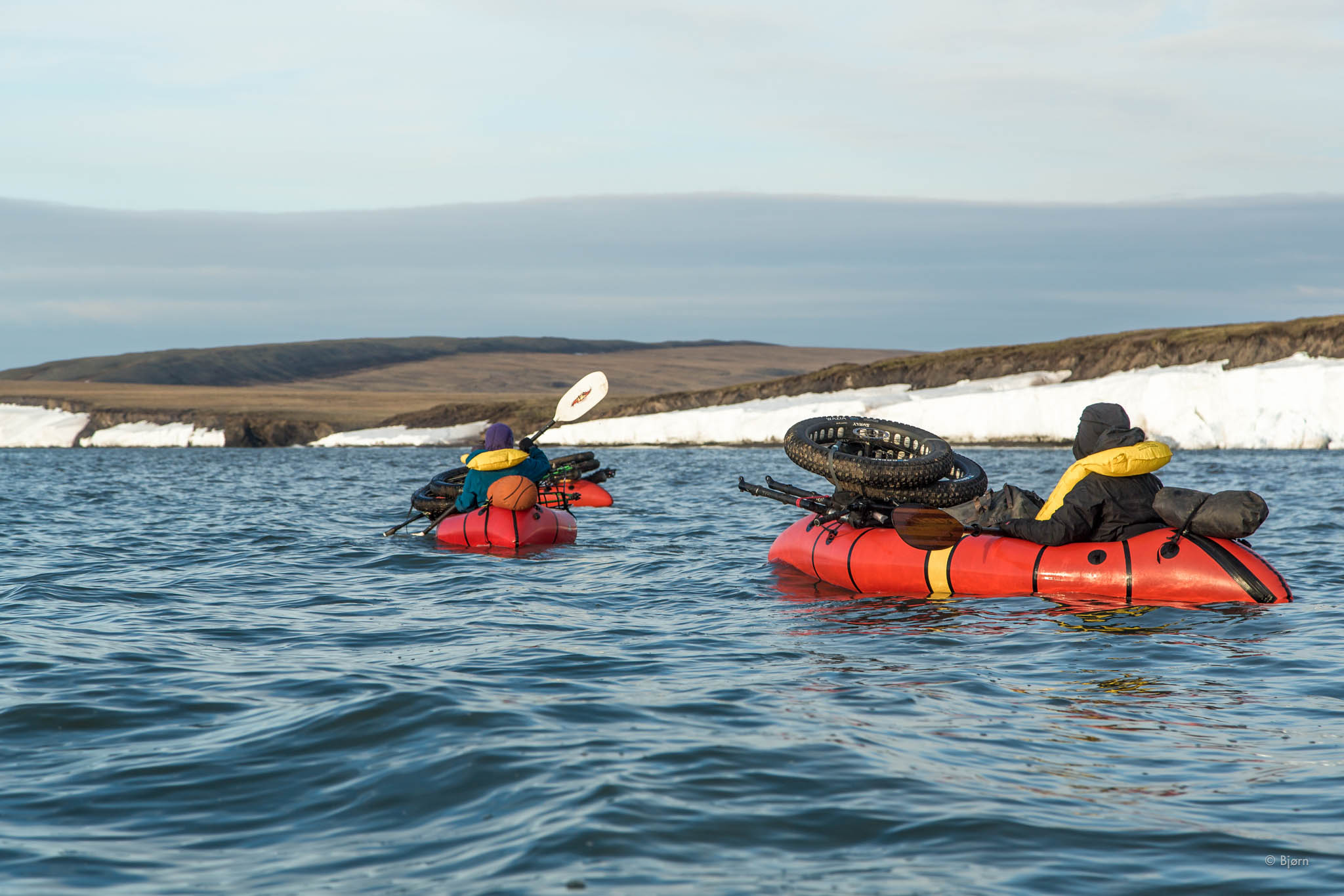 Kim, Alayne, and Daniel packraft in front of the Corwin Bluffs - Arctic Alaska. 