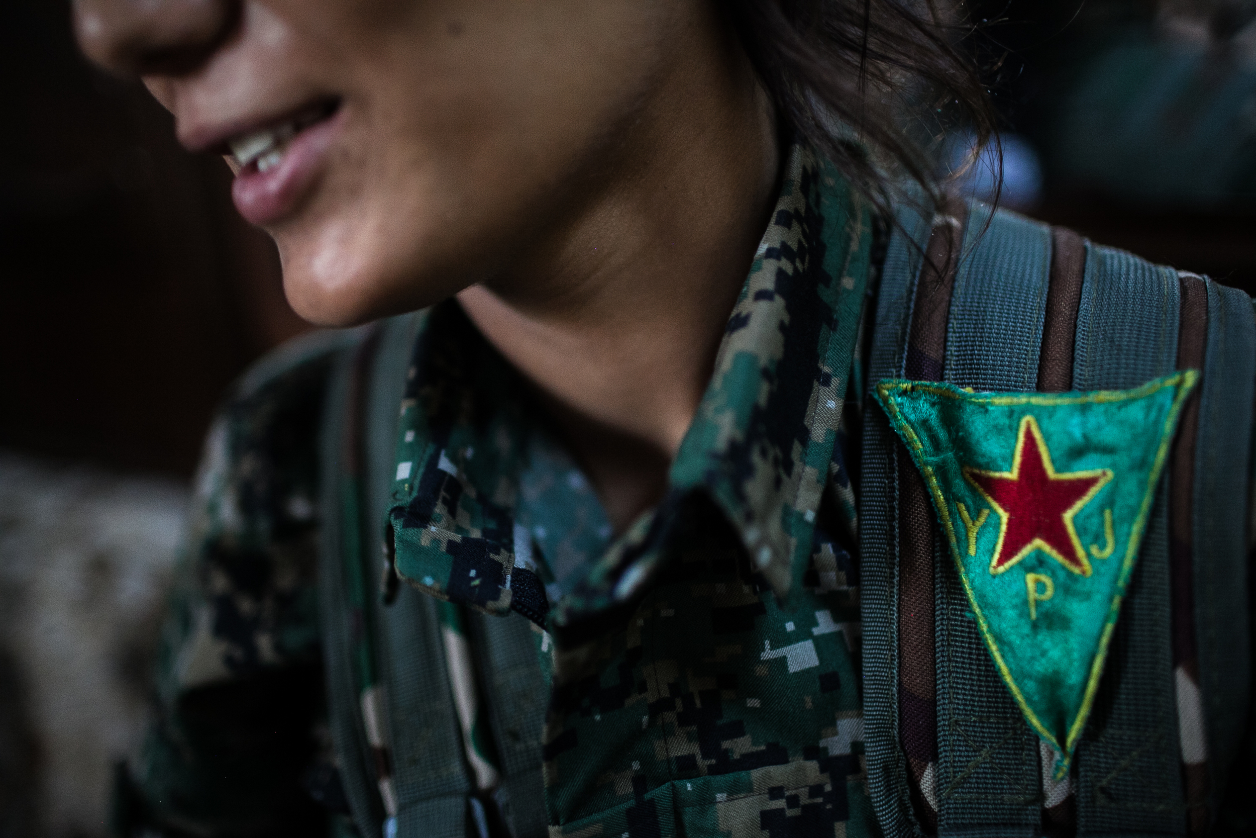  YPJ soldier, Amara, wears a red, yellow and green patch, the official flag of the YPJ, on her uniform near Girke Lege, Syria. 
