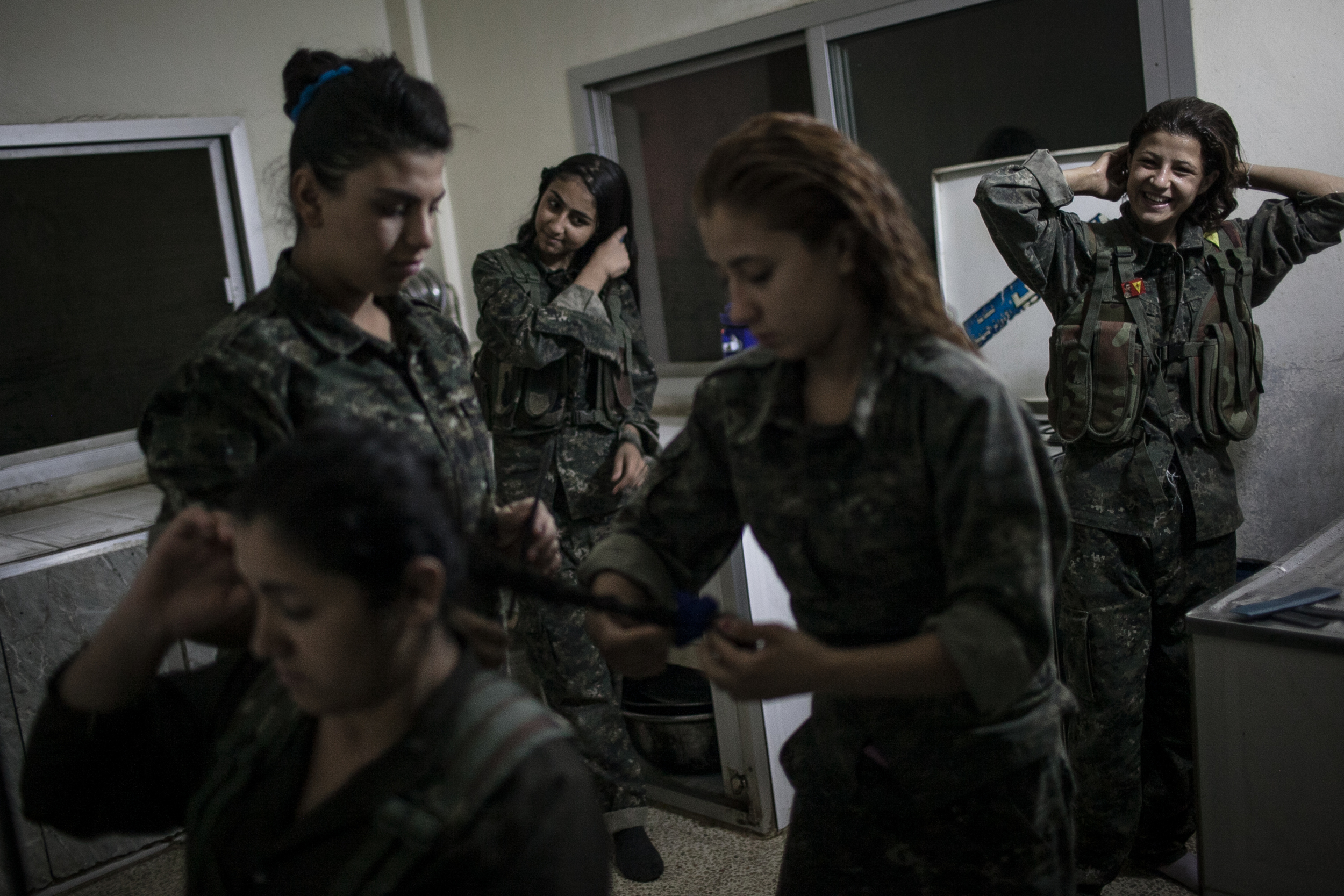  Young YPJ recruits fix their hair at 4:30 AM before training drills near Derek City, Syria.  