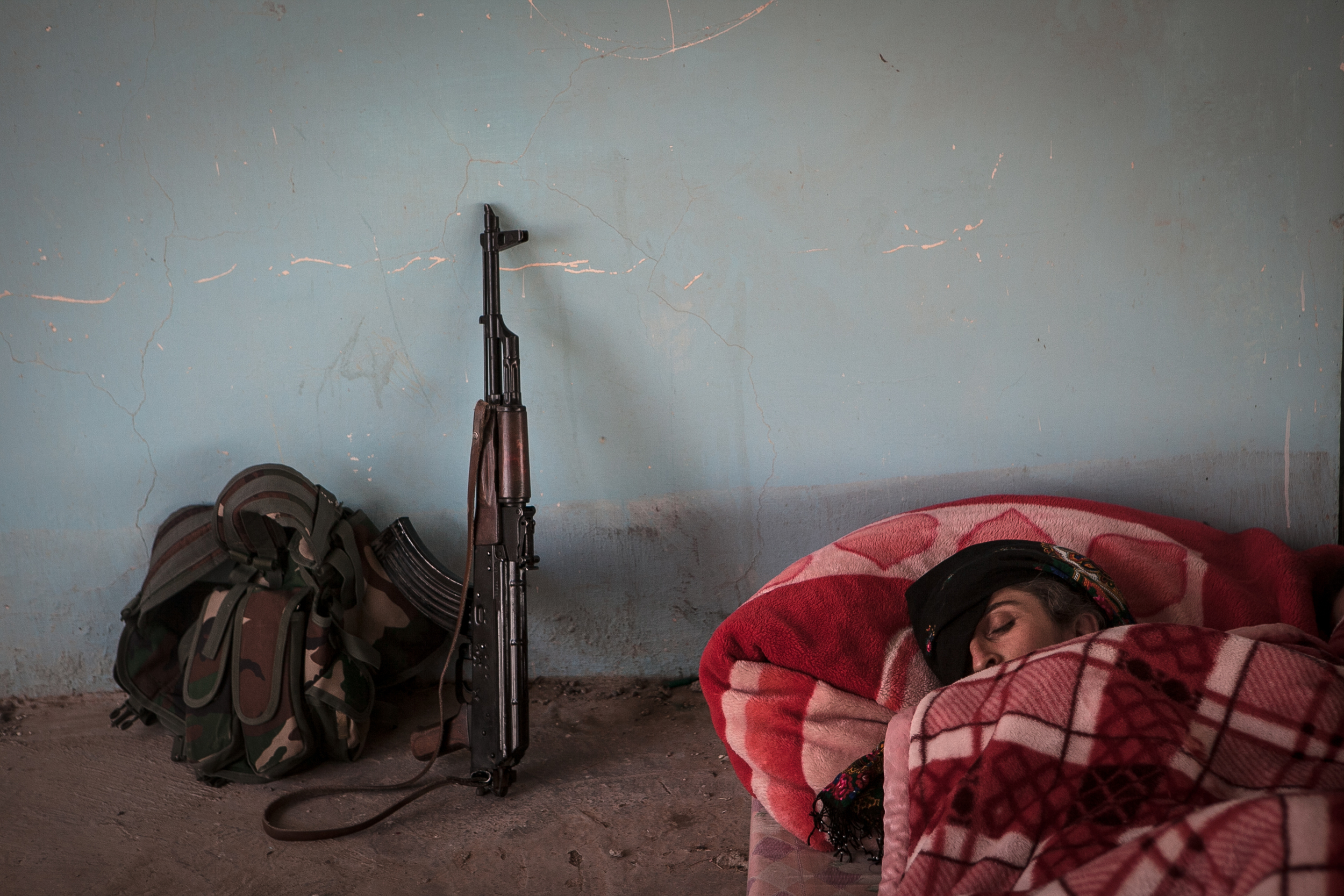  YPJ soldier Shavin Bachouk sleeps at an abandoned army post on the outskirts of Raabia, Iraq. Many YPG / YPJ soldier stake out at on the Syrian-Iraq border to fend of ISIS attacks. 