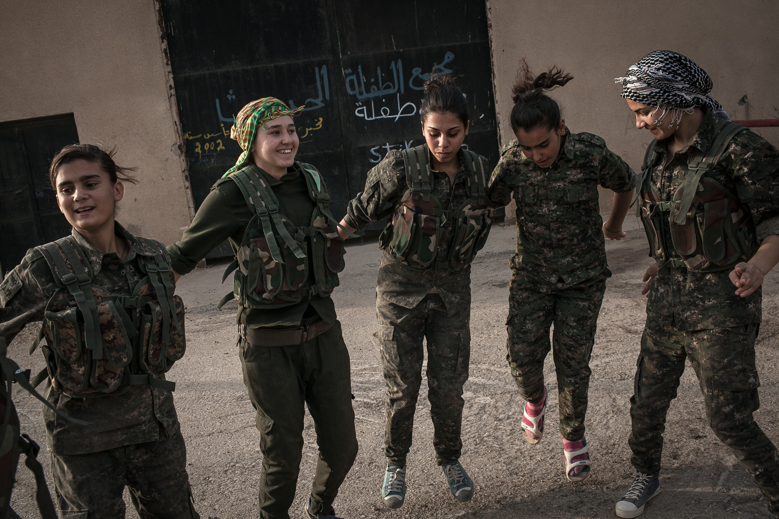  YPJ recruits dance and sing traditional Kurdish songs at dawn near Derek City, Syria. 