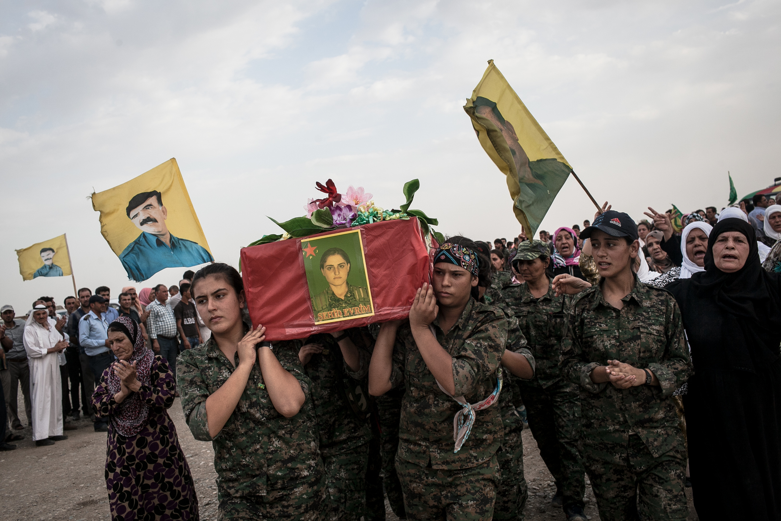  YPJ members carry the coffin of a fellow soldier who was killed by ISIS at a funeral along the Syrian-Iraq border. 