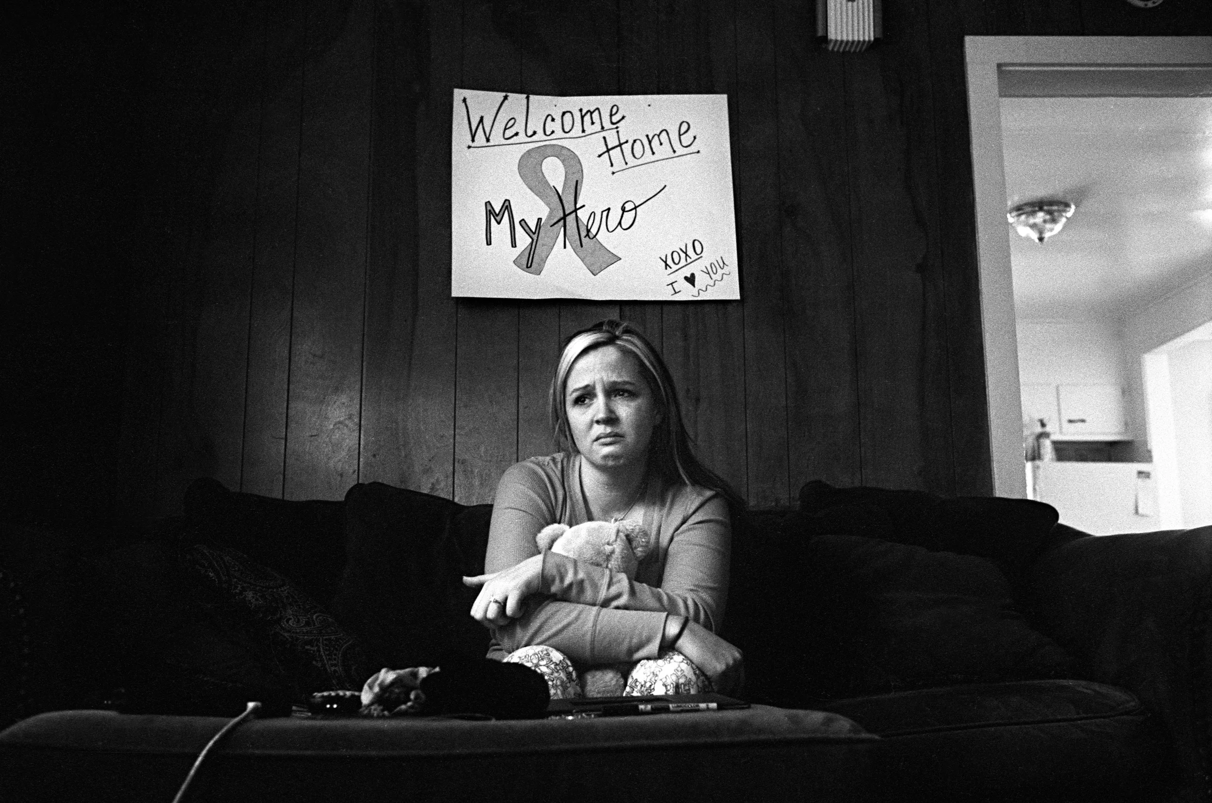 Stefanie Strausser cries under a "welcome home" sign she made for her fiancé SSG Cody Anderson, 25, who was found dead in his apartment in Watertown, New York, 2010.