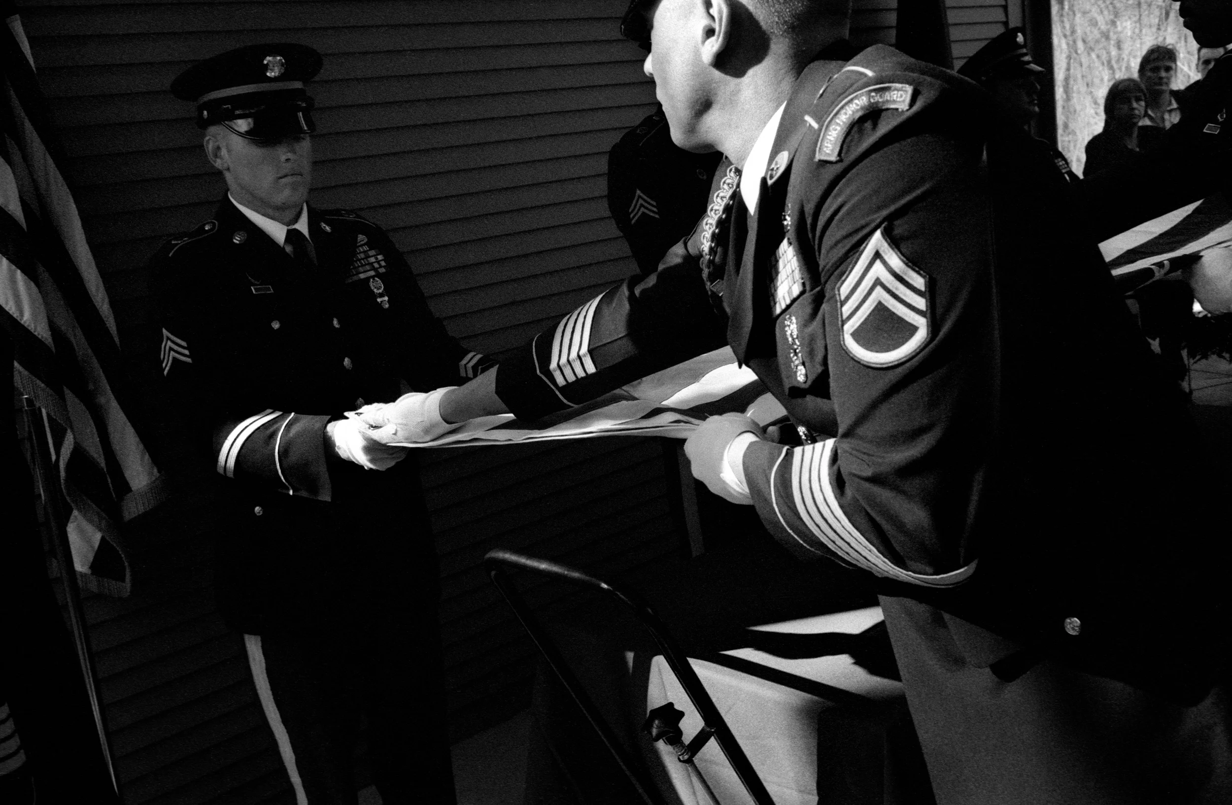 National Guard soldiers fold a flag at the funeral of SPC Dirk Terpstra who committed suicide shortly after returning home from Afghanistan; Ft. Custer National Cemetery, Augusta, Michigan, 2010. The night of his death, Terpstra visited a bar with friends where he became drunk and then shot himself in a neighbor's front yard.