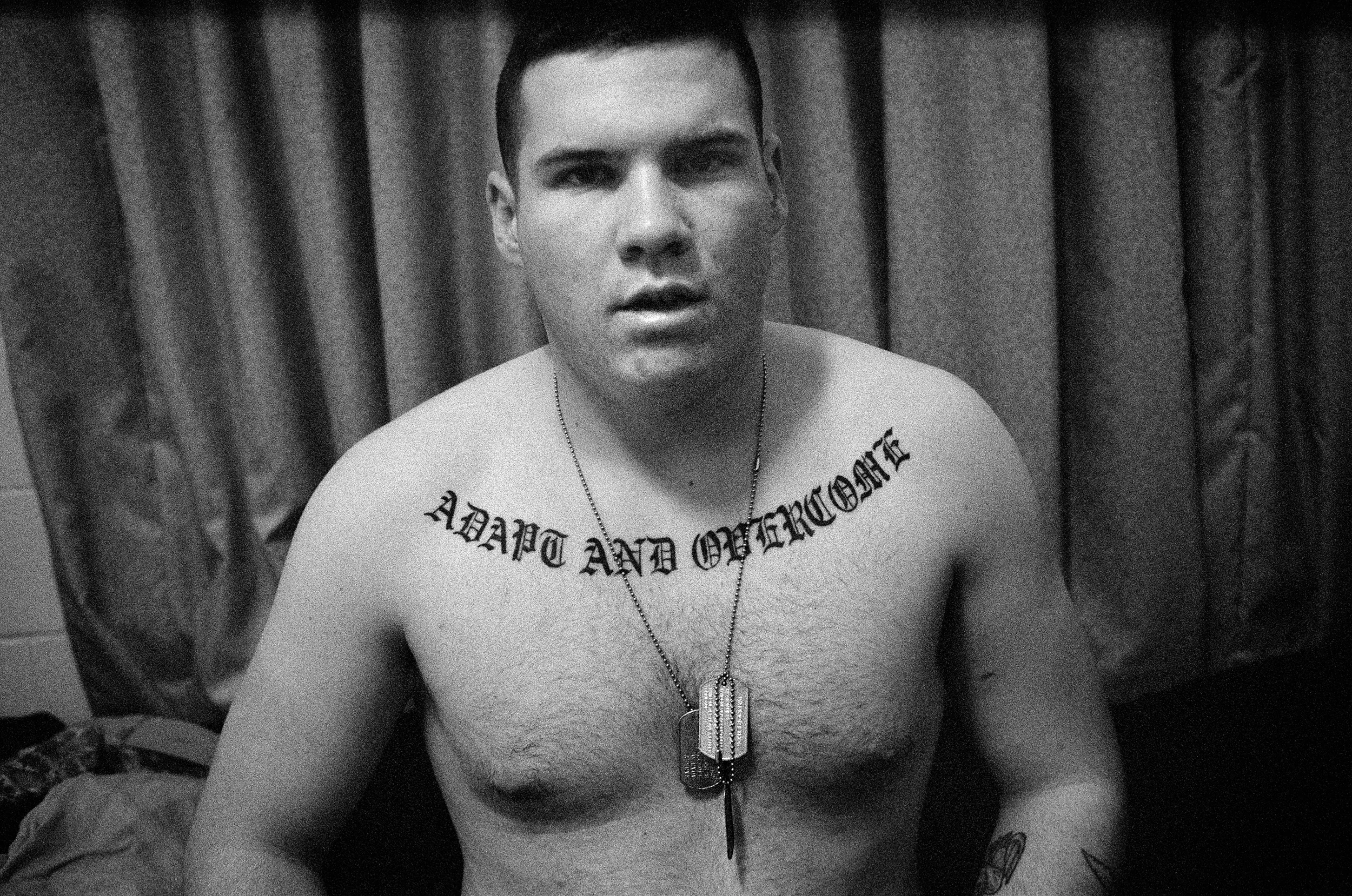 SPC Adam Ramsey, his tattoo reading "adapt and overcome", on his bed in the barracks at Fort Drum, New York, 2010.