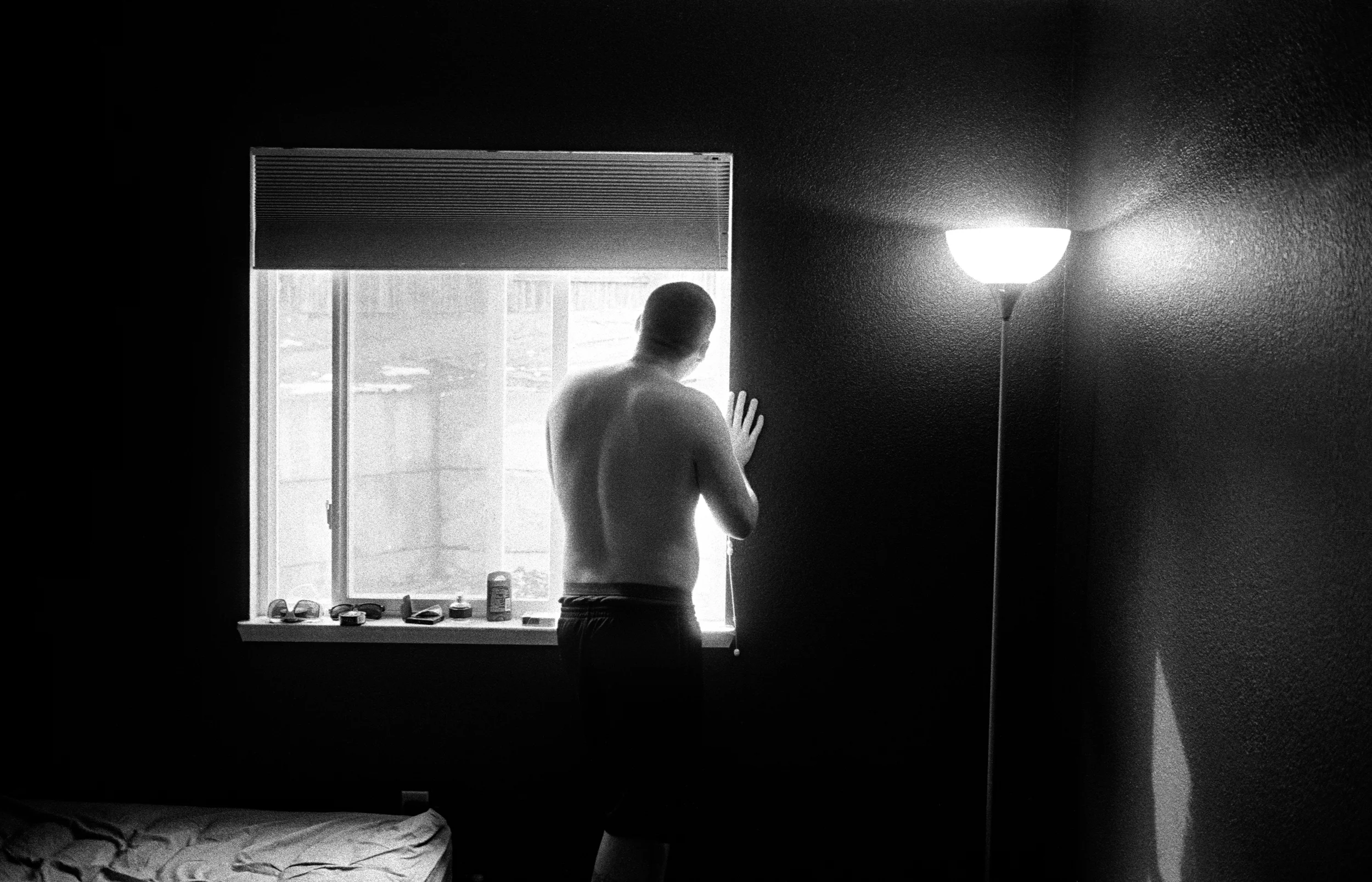 SPC Adam Ramsey, 22, looks out the bedroom window as he experience a psychotic episode in Carson City, Nevada, 2010. Ramsey served 12 months as a 240 machine gunner in Afghanistan. After returning home he became severely depression and began having psychosis and and suicidal thoughts.