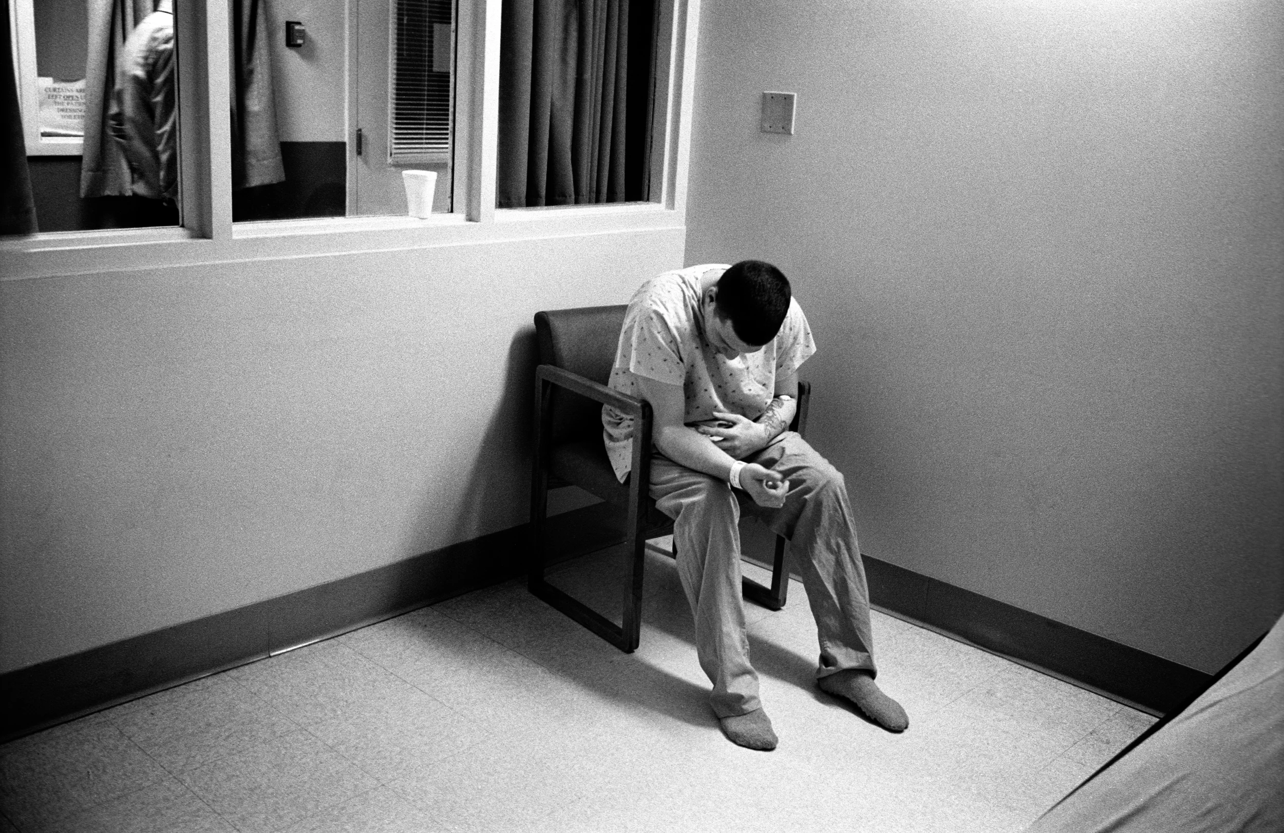 After checking himself in to a hospital, SPC Adam Ramsey examines the lacerations on his arm where he cut himself; Watertown, New York, 2010. 