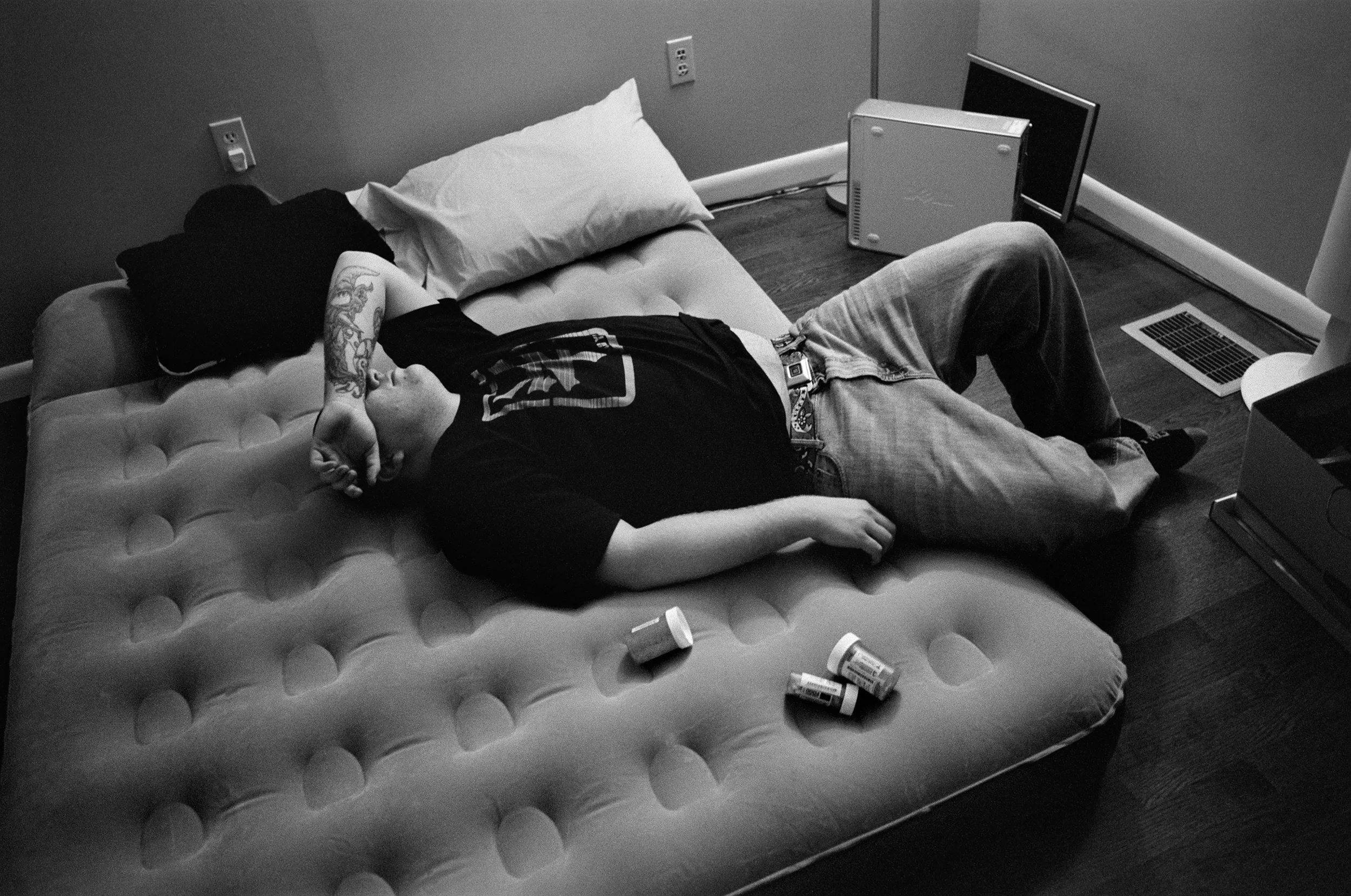 SPC Adam Ramsey lies exhausted on his air mattress bed with his prescription medications after packing to leave Watertown, New York in January 2011.