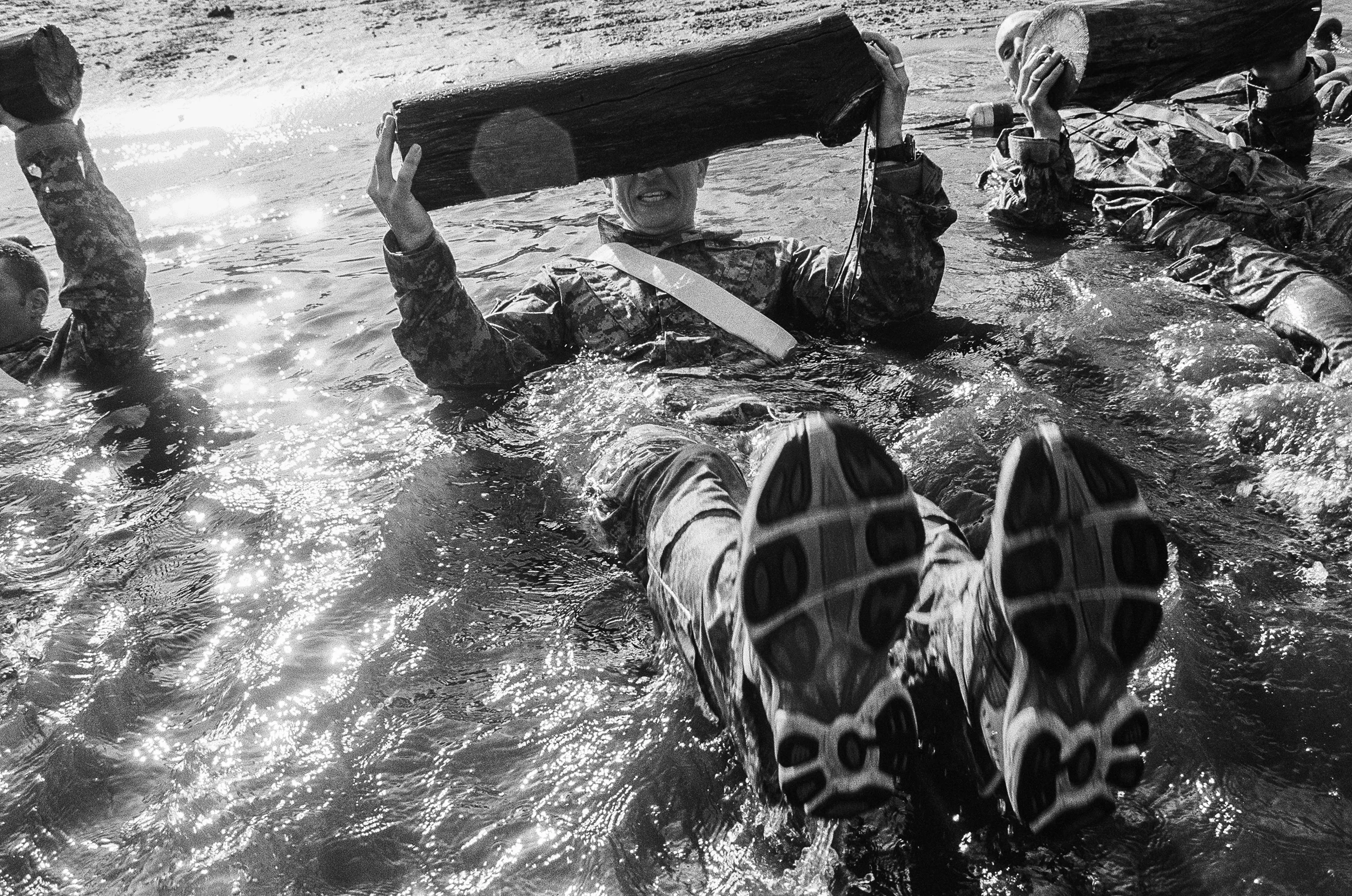 LT John Cote swims with a log during a training drill at Fort Drum, New York, 2010.