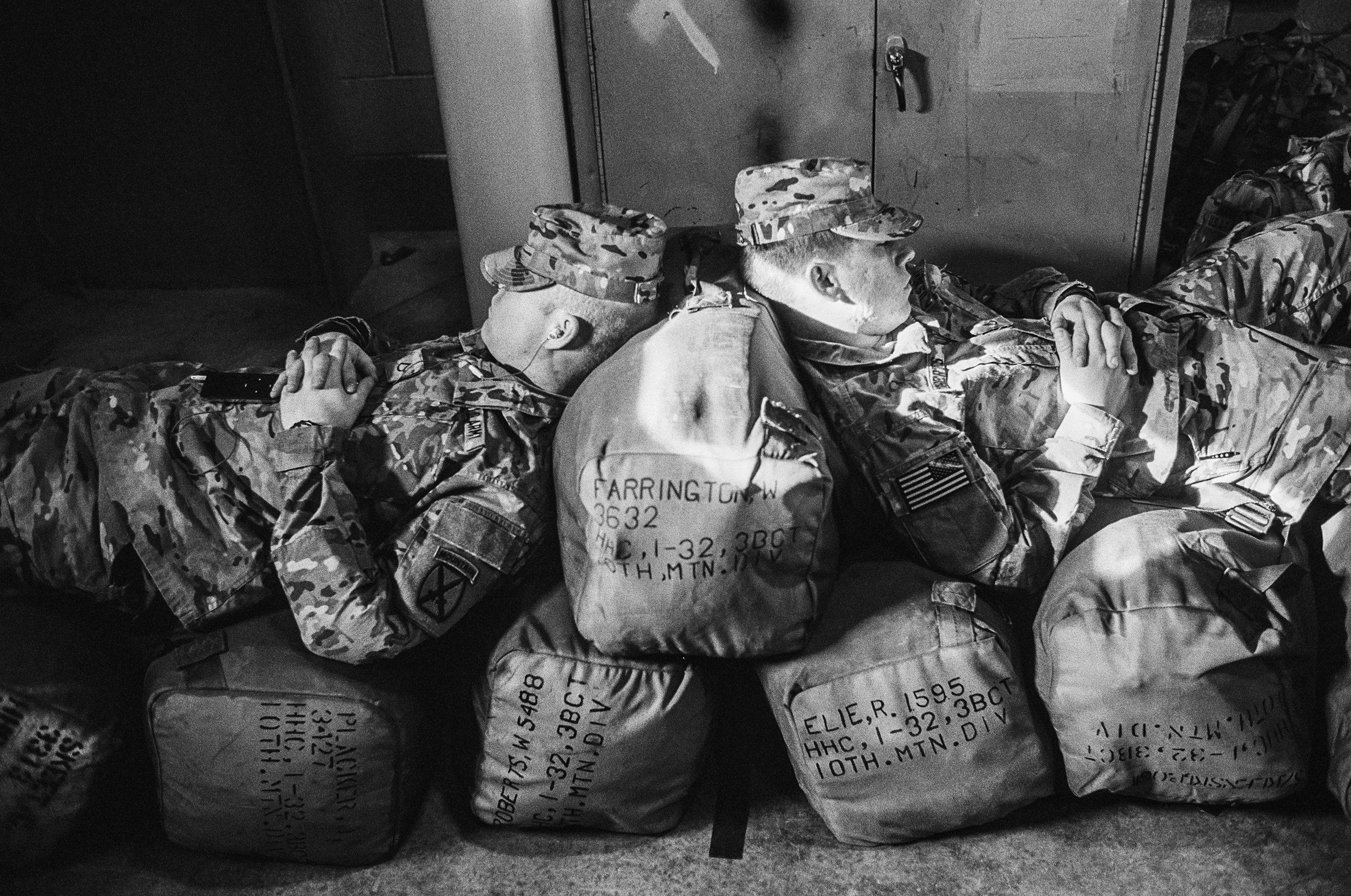  Two soldiers naps on their duffle bags before deploying to Afghanistan at Fort Drum, New York,&nbsp;2011. 