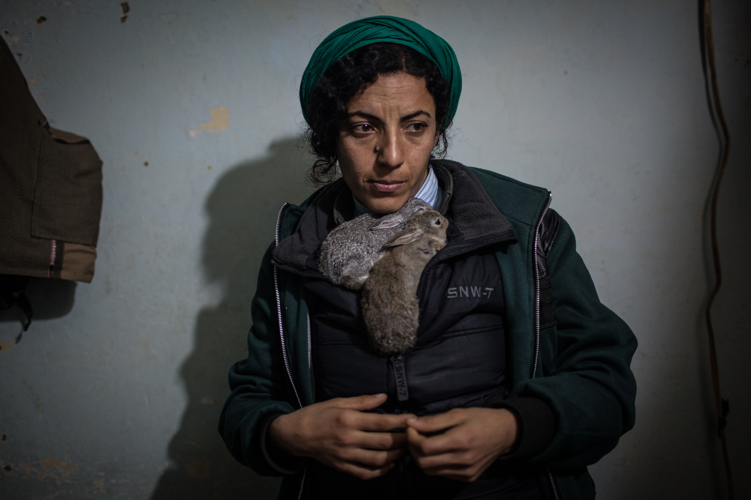  A YPJ Soldier cradles two pet bunnies, Sinjar, Iraq.  