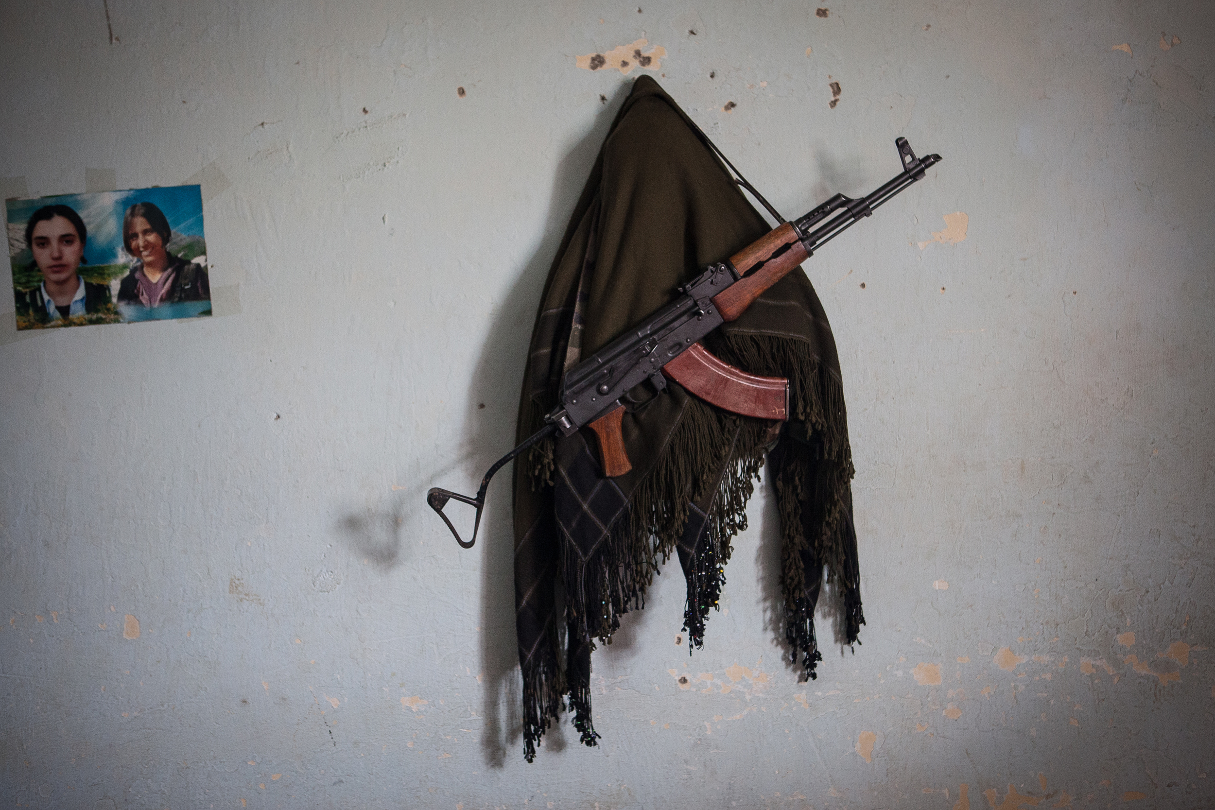  A PKK guerrilla’s traditional scarf and AK-47 hang on the wall of a ou-post near Sinjar, Iraq.  