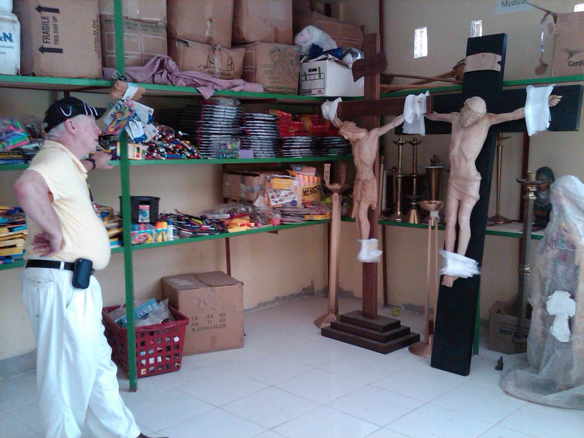 Fr. Tom in looks at donated crosses in our depot