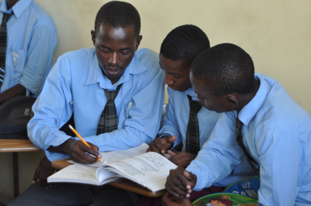 Senior boys share an exam study book