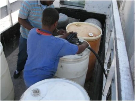 Filling eight, 60 gallon drums with diesel fuel from the World Food Program.