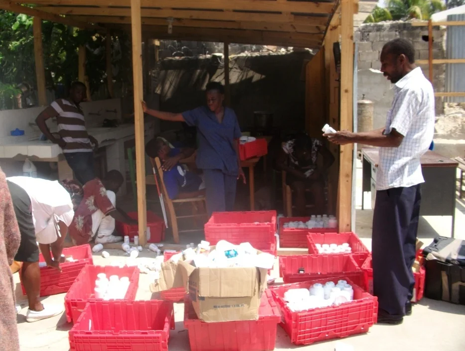 HT staff sort through donated meds, preparing for the daily clinic.