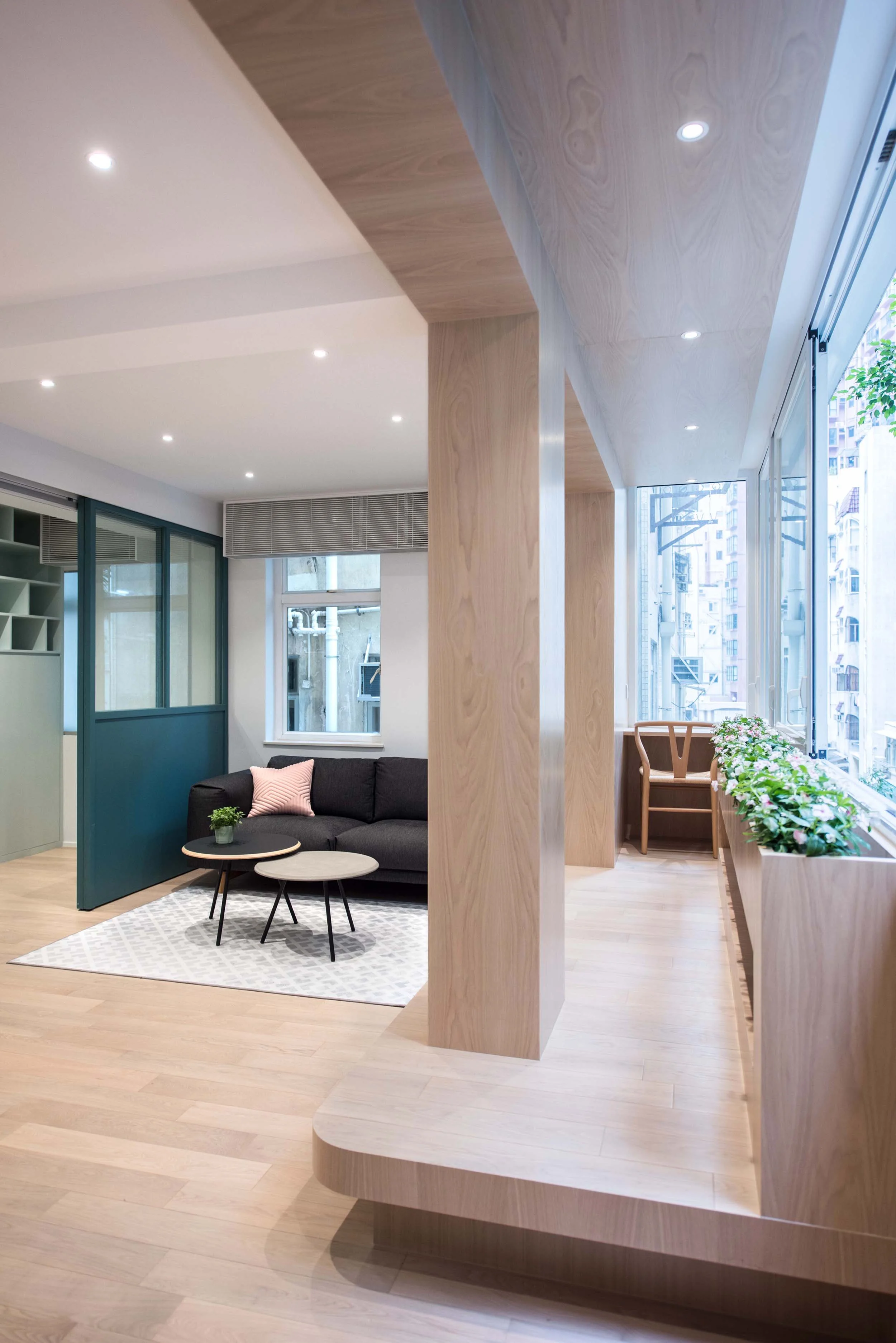 The area along the window is conceptualised as a large wooden ‘theatre box’, with a raised platform and large operable windows for bird viewing, street watching, exercising, working, and gardening. Lined entirely in timber, the geometry also creates an intimate personal work point with a built in table at one end, which has a corner window that faces down the street. The timber element creates an opportunity for planters below the window sill, and a long bookshelf niche at the low level of the planters. The raised platform is also considered as a seating space with cushions for guests as part of the lounge sofa set. Passersby from the street may be able to look up and see the ceiling of the wooden ‘theatre box’, but not able to see the activities inside. It is at the intersection of the visible and the invisible.