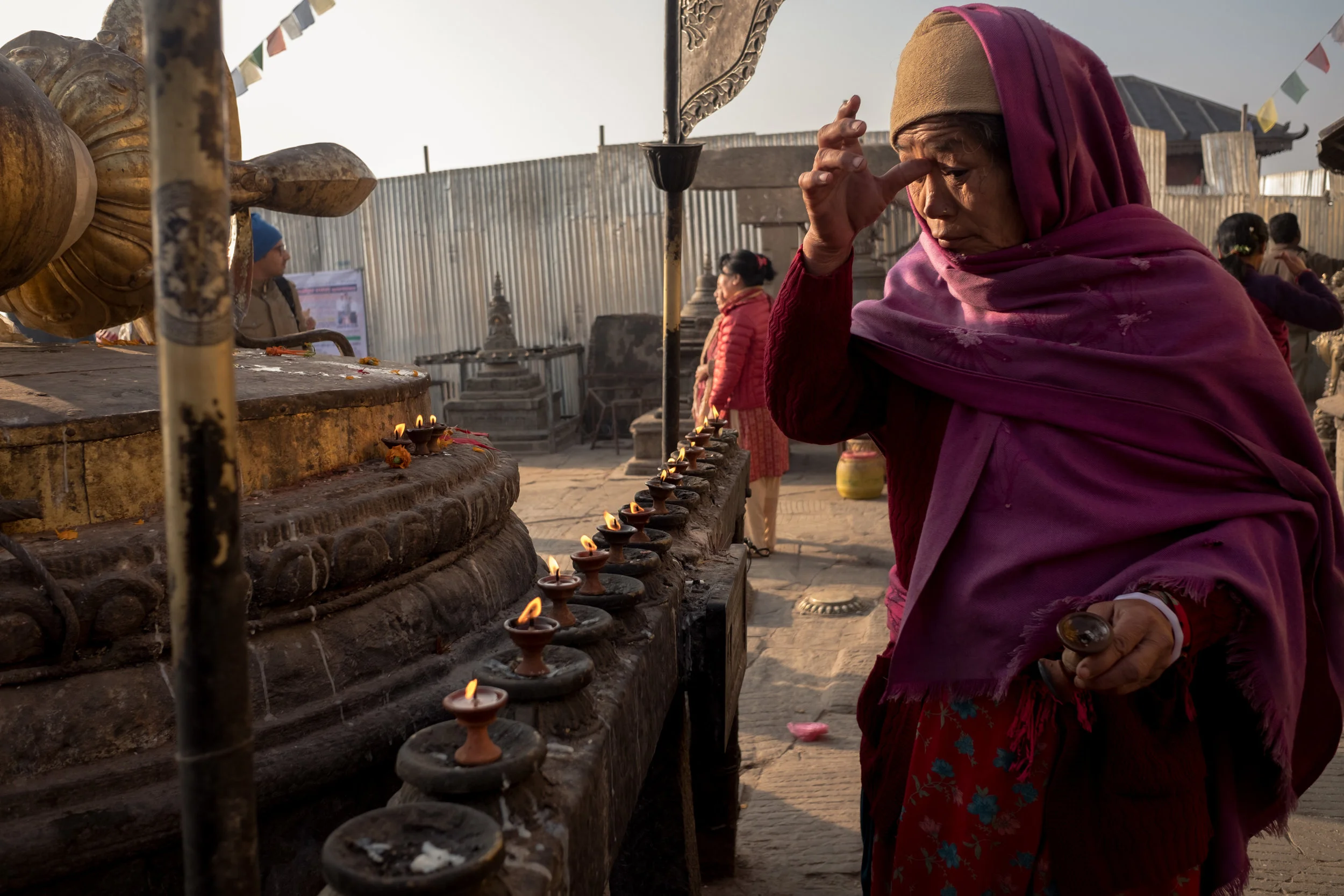 A lady touching her forehead in Swayabhunath.