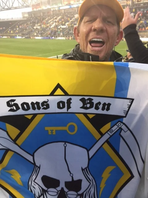 I am a longtime Internet Solutions Consultant, Systems Admin, App Developer, and all around geekophile. Shoot, I even broke down and bought an Apple Watch. In my free time, I'm the SoccerMom from hell, a Little League Umpire, and Facilities Manager for our local Sports Complex. I have been a loyal SOB since 2009. My 11y/o Ben Franklin and I have been known to frequent sections 135 and 133 in the past, before settling a few seasons ago in 138. Opposing clubs must also fear my wrath in their own house, as I try to get to a few away matches a year, as well. I have never had a bad time standing with the Bens for getting on seven seasons, and have always shared my experiences through Social Media. Feel free to hit me up @sidmacleod on most of the usual suspects, including but not limited to, FB, Twitter, Instagram, G+, Yelp, GrubHub... I would be a natural fit to serve as Social Media Director for the #SonsOfBen. Those of you that know me know that I love having a good time, and I would love to share with more of you, I'm just a sharing kind of guy. Ha. But seriously, I would like to see more of us using Social Media to share videos, pictures, and even text of their SOB experience. Ok, if that did t work, I'm offering Free Beer*! *actual prices may vary