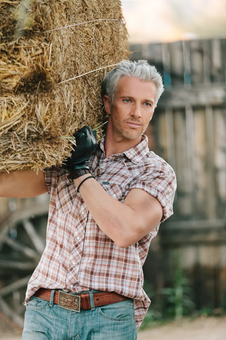 man carries bay of hay.