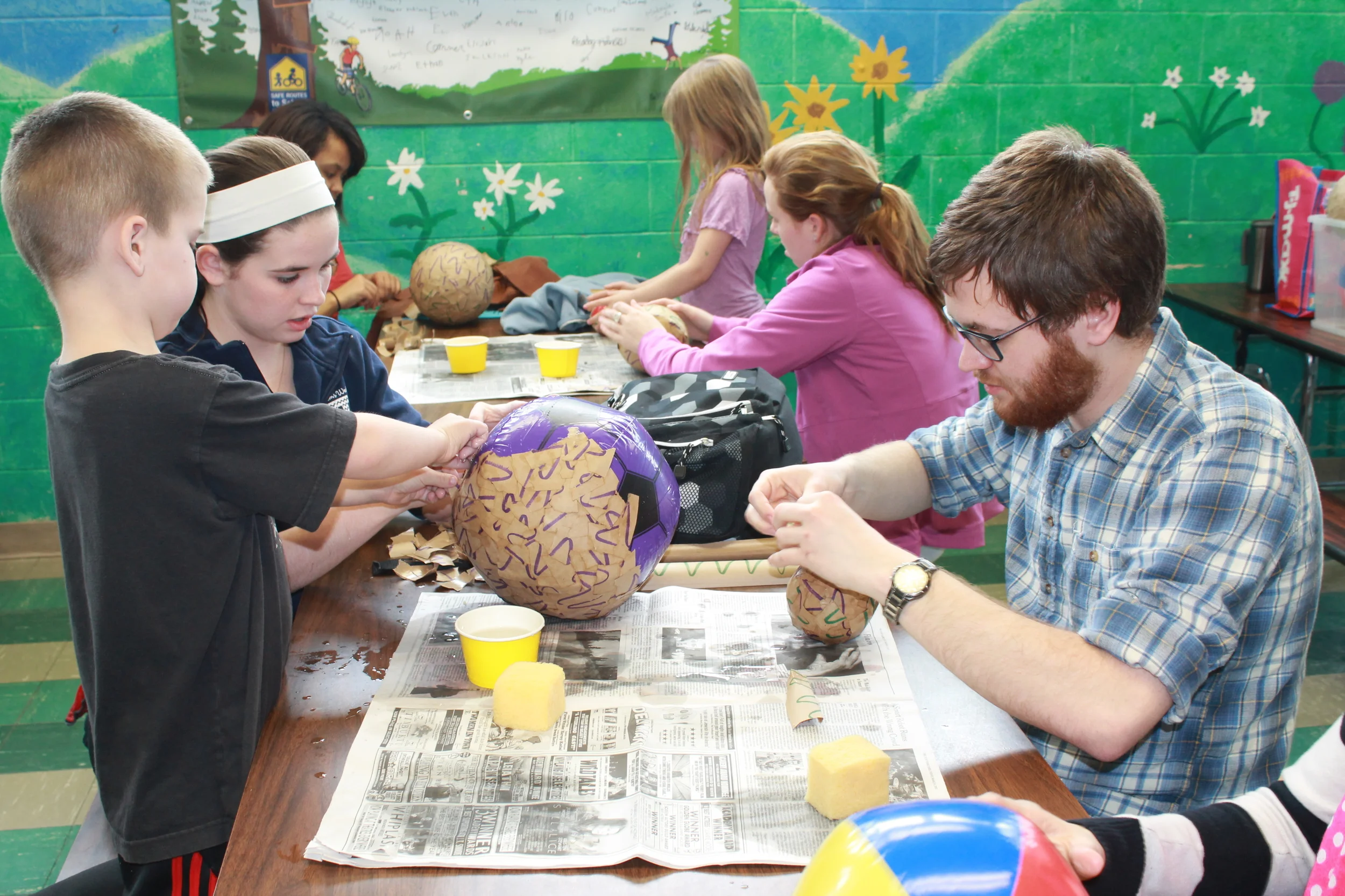 One of our physics students, Ben, jumps in to lend a hand with the making of the planets.