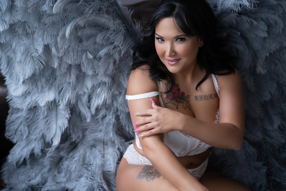 Latina woman over 40 wearing angel wings and lingerie for a boudoir photo at Demi Girl Photography.