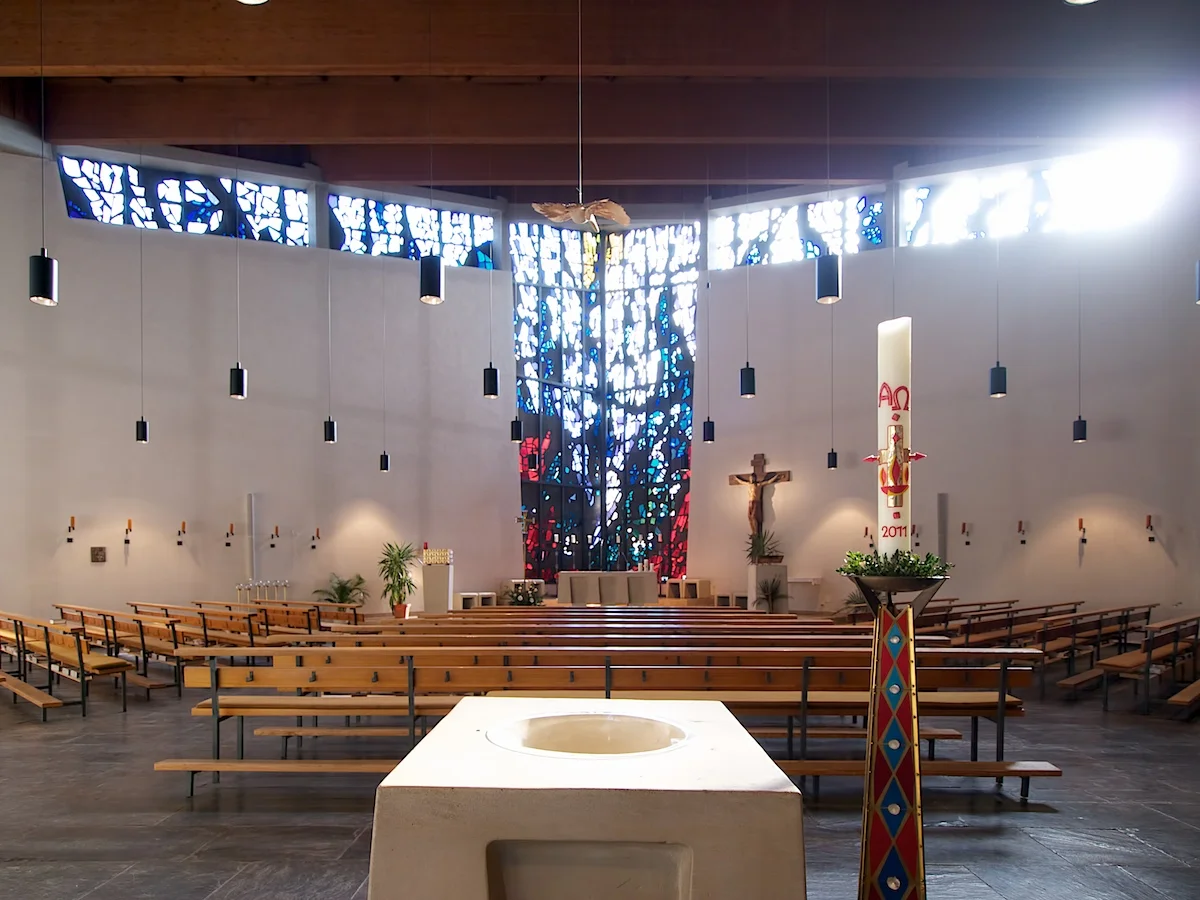 Taufbecken, Taufkerze und Kirchenraum in St. Michael.