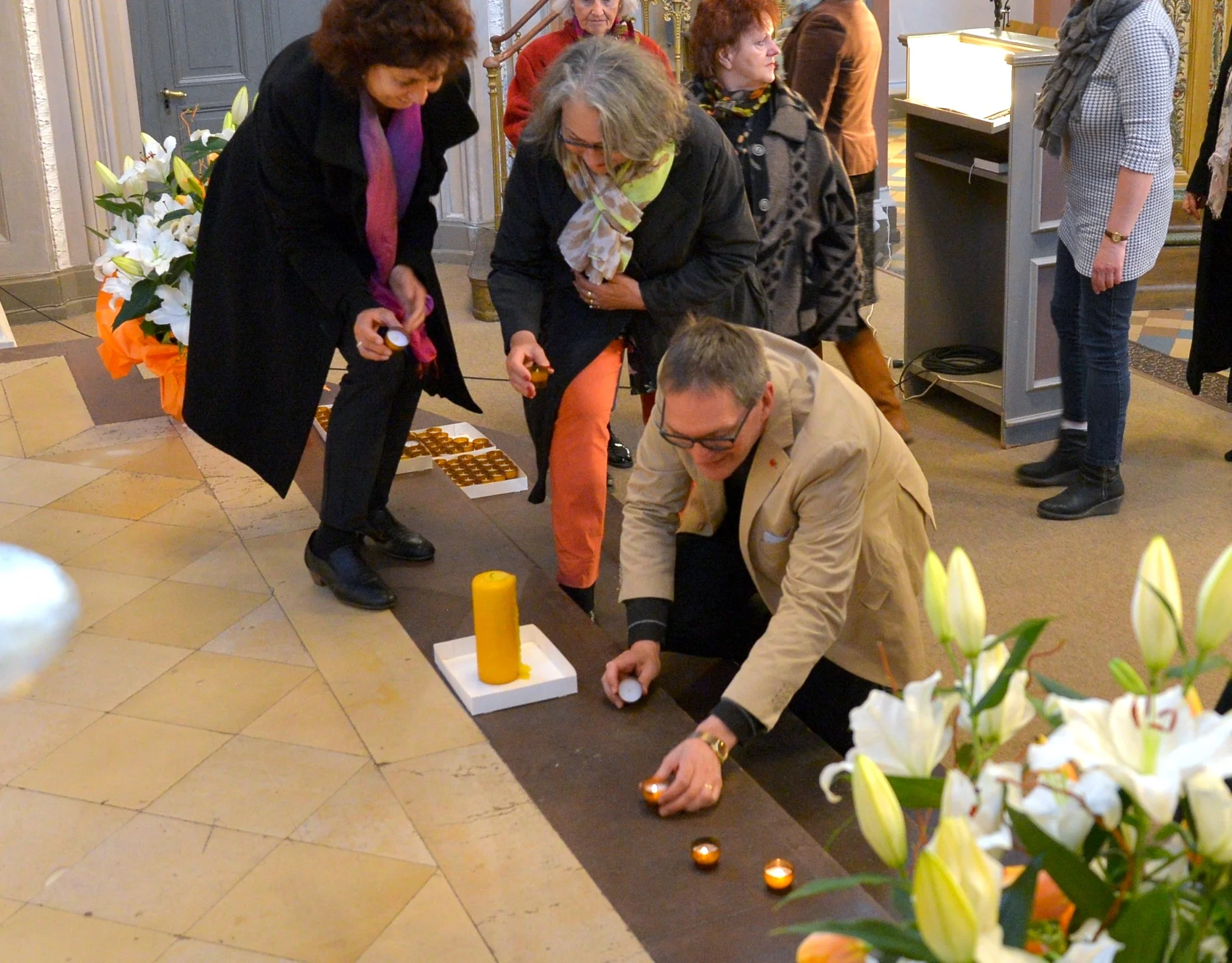 Als Symbol für den Frieden zündeten die Besucherinnen und Besucher in ökumenischer Verbundenheit auf den Treppen vor dem Altar in der Marktkirche eine Kerze an. Foto: Andrea Wagenknecht/Ev. Dekanat Wiesbaden