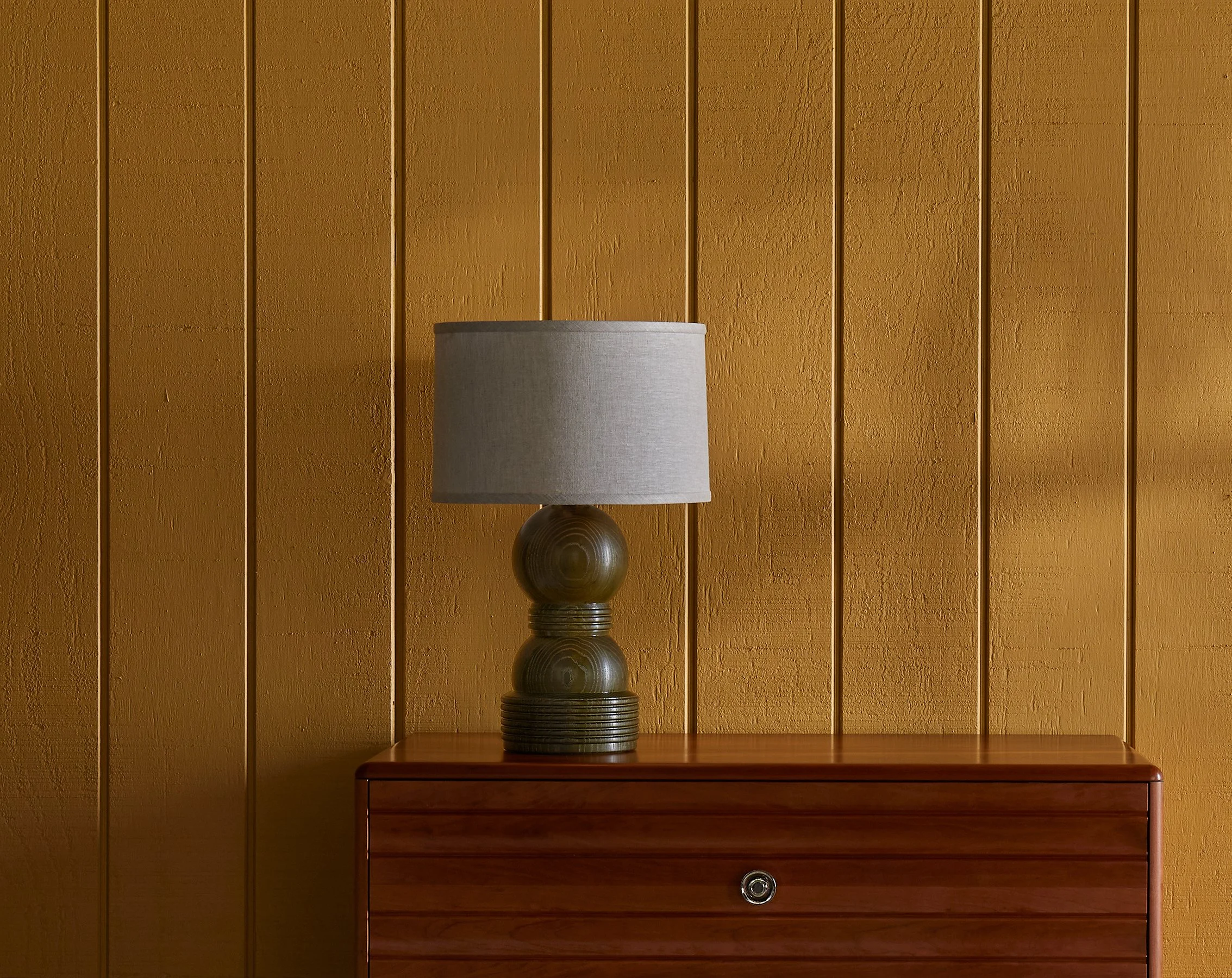The O&G Cassia Lamp in Kelp on Ash sitting on an Edda Dresser in Natural Cherry