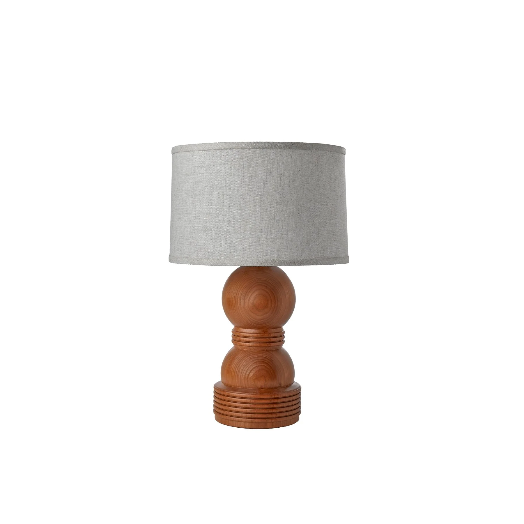 The Cassia Lamp shown in natural cherry is a made-to-order solid hardwood table lamp from O&G Studio, available in ash stain finishes, natural cherry, and natural walnut with a linen shade.