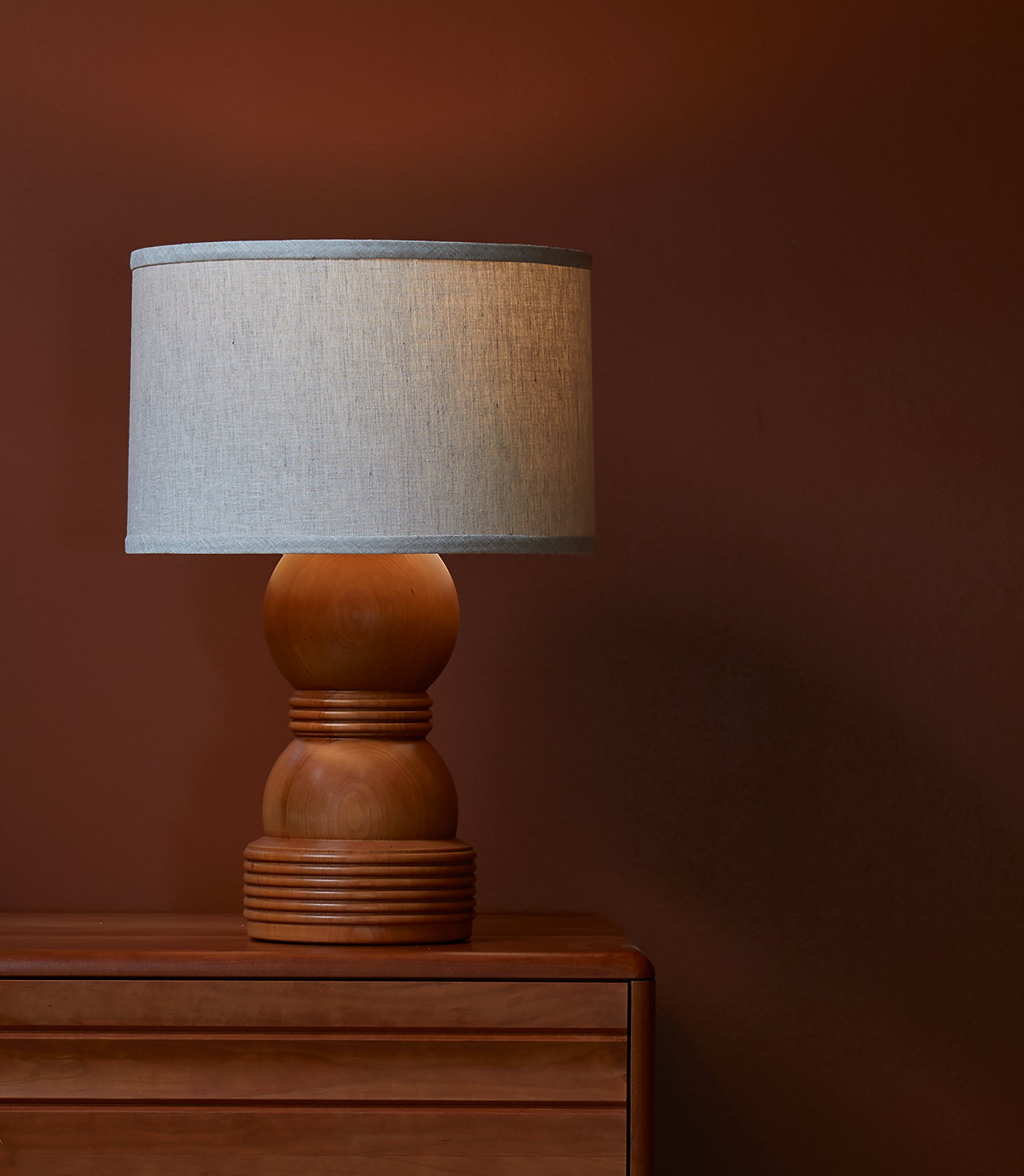 The O&G Cassia Lamp in natural cherry sitting on an Edda Dresser in Natural Cherry
