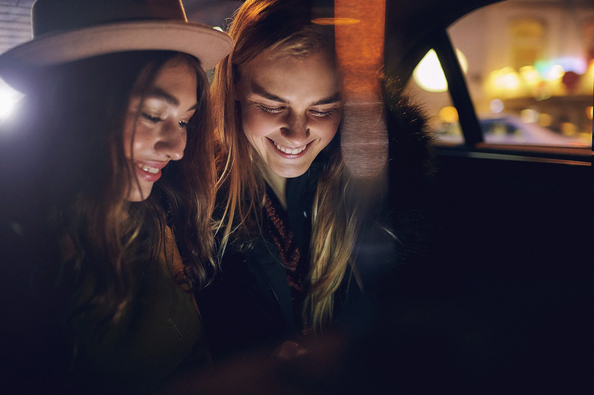 girls in back of taxi on phone
