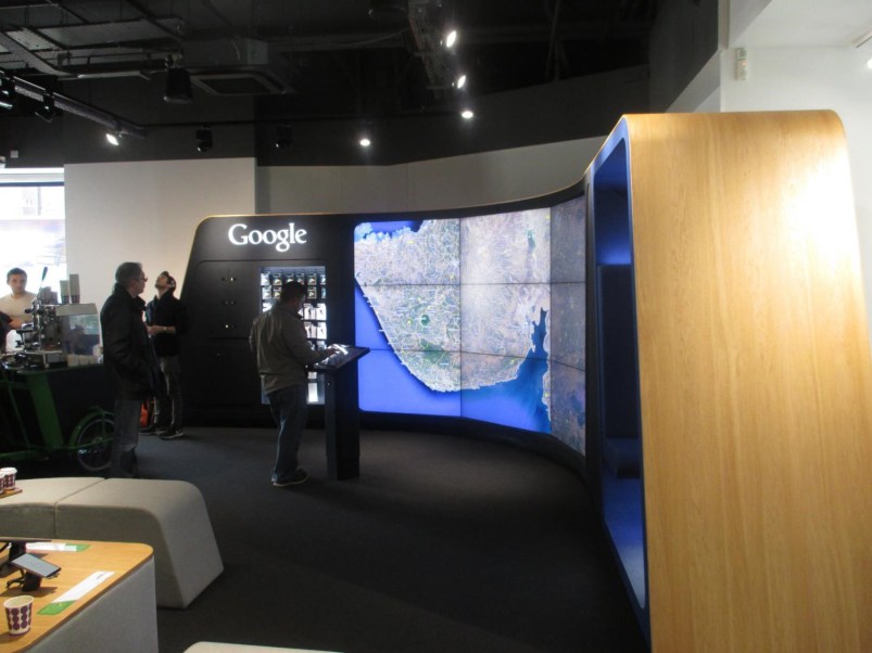 Curved video wall (showing Google Earth), controlled by an interactive pad