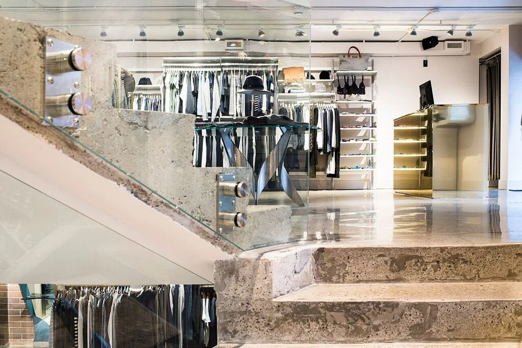 Brutalist concrete contrasting with metal and glass in women's wear.