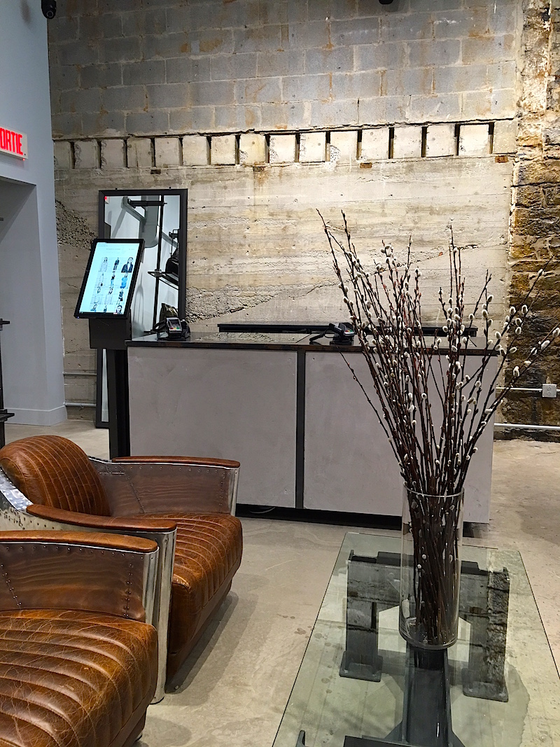 Cash desk, exposed concrete walls, leather/metal furniture. Product not available in the store can be ordered on the screen in the photo, to be shipped the next day.&nbsp;Photo:&nbsp; Maxime Frechette .