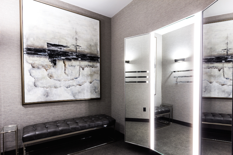 Large dressing room, featuring luxurious wall coverings, leather seating and artwork.&nbsp;
