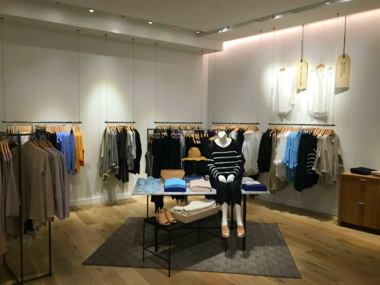 Simple, elegant hanging racks against white walls at Sherway's Eileen Fisher store.&nbsp;Photo: Pace Construction