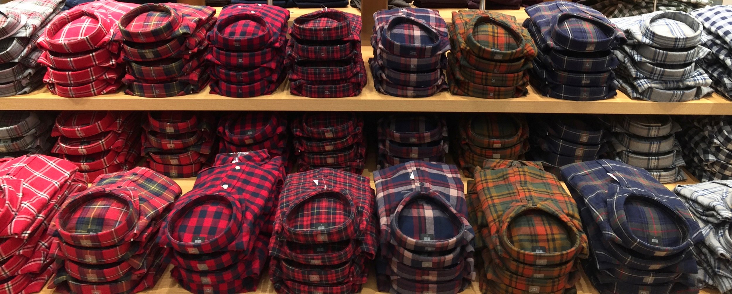 Flannel shirts are stacked by colour on the front display table. Photo: Devon Johnson