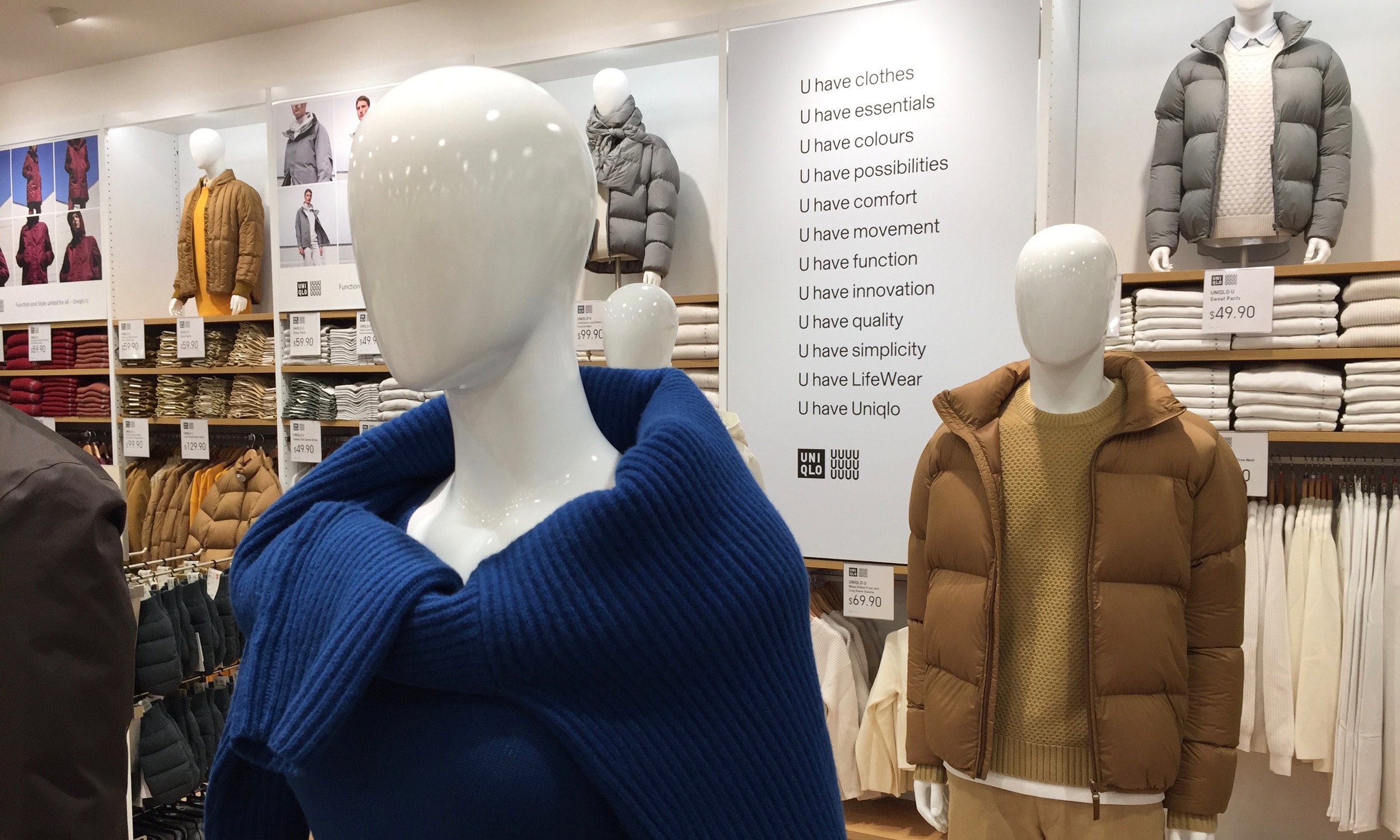 A ladies blue sweater and mens beige jacket are both part of Uniqlo U