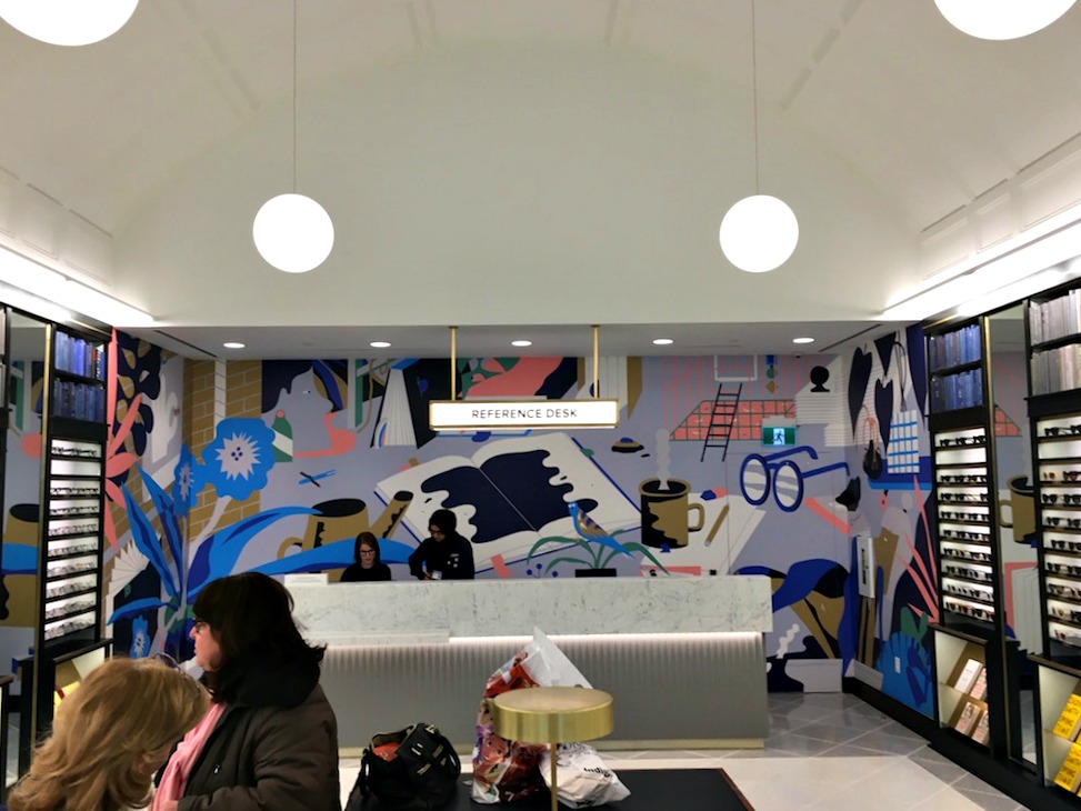 (Looking towards the art-adorned 'Reference Desk' at the back of the store) 